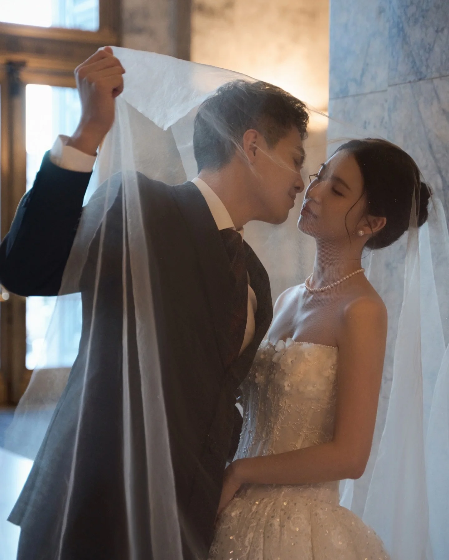 The city was cold.
The vows were warm.

Marble walls echoed every step,
and somehow made each heartbeat louder.

Under the arches, the lights breathed in gold.
The wind lifted the edge of your veil.
You turned back to look at me&mdash;
and in that se