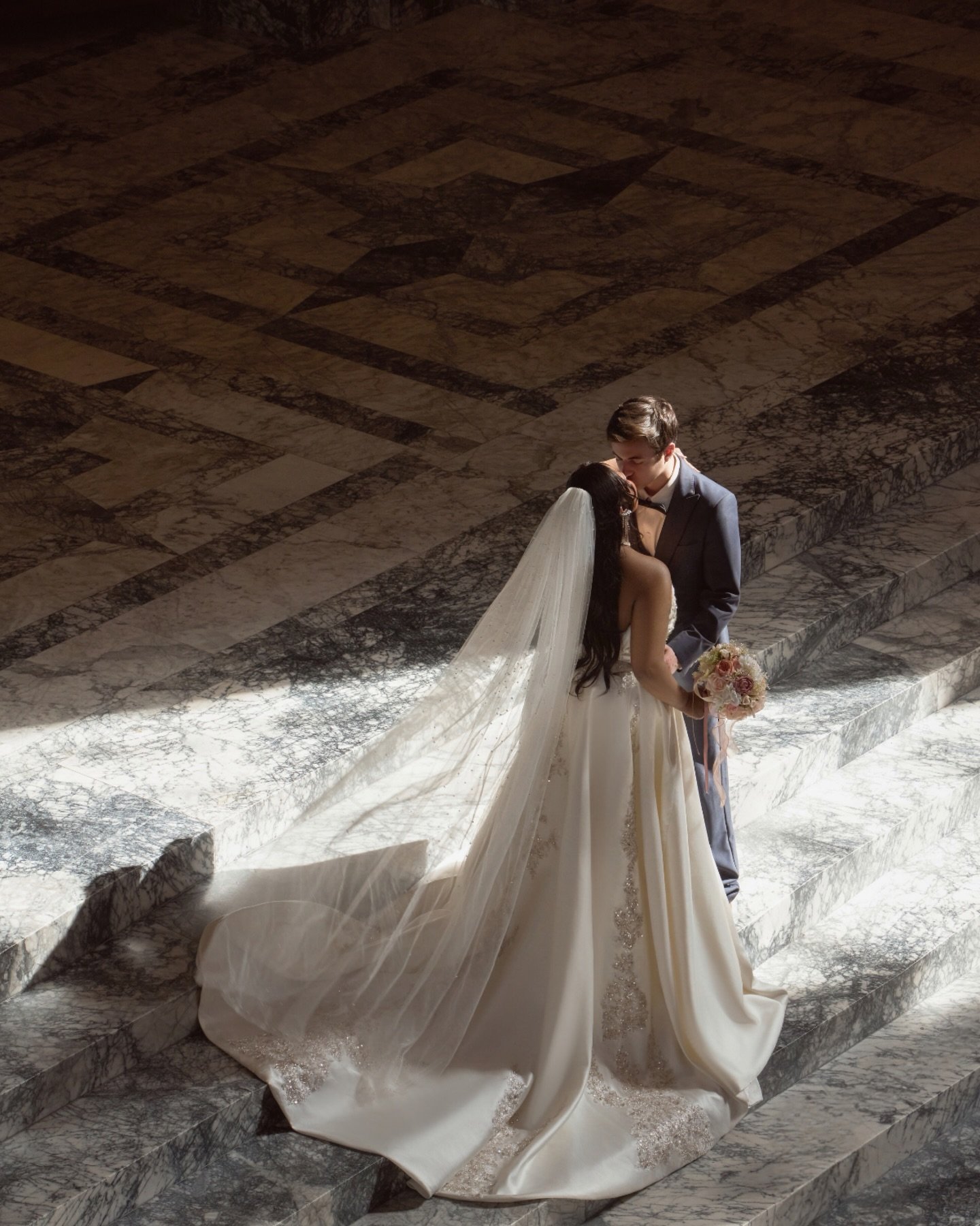 Light cuts through the dome,
falling across the deepest folds of her gown.
Her veil was still mid-air when she started to smile.
That small moment in between is what love really looks like.

Like a scene slowed down, like a quiet kind of romance，
whe