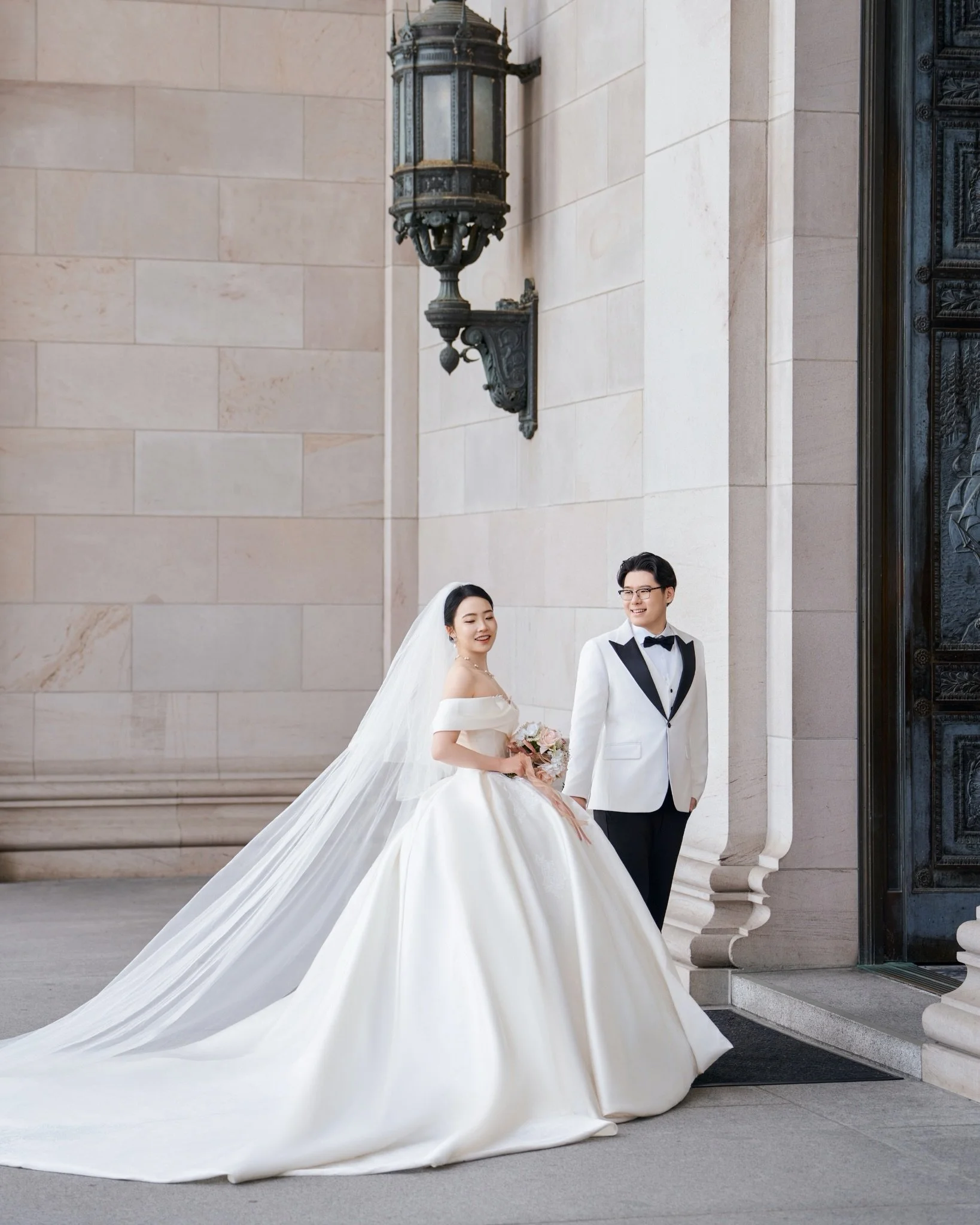 Olympia gave them spring in two forms:
petals moving in the wind,
and quiet light resting on her veil.

There was something timeless about this day.
The grand staircase, the dome, the soft pink blooms,
all holding space for a promise that felt simple