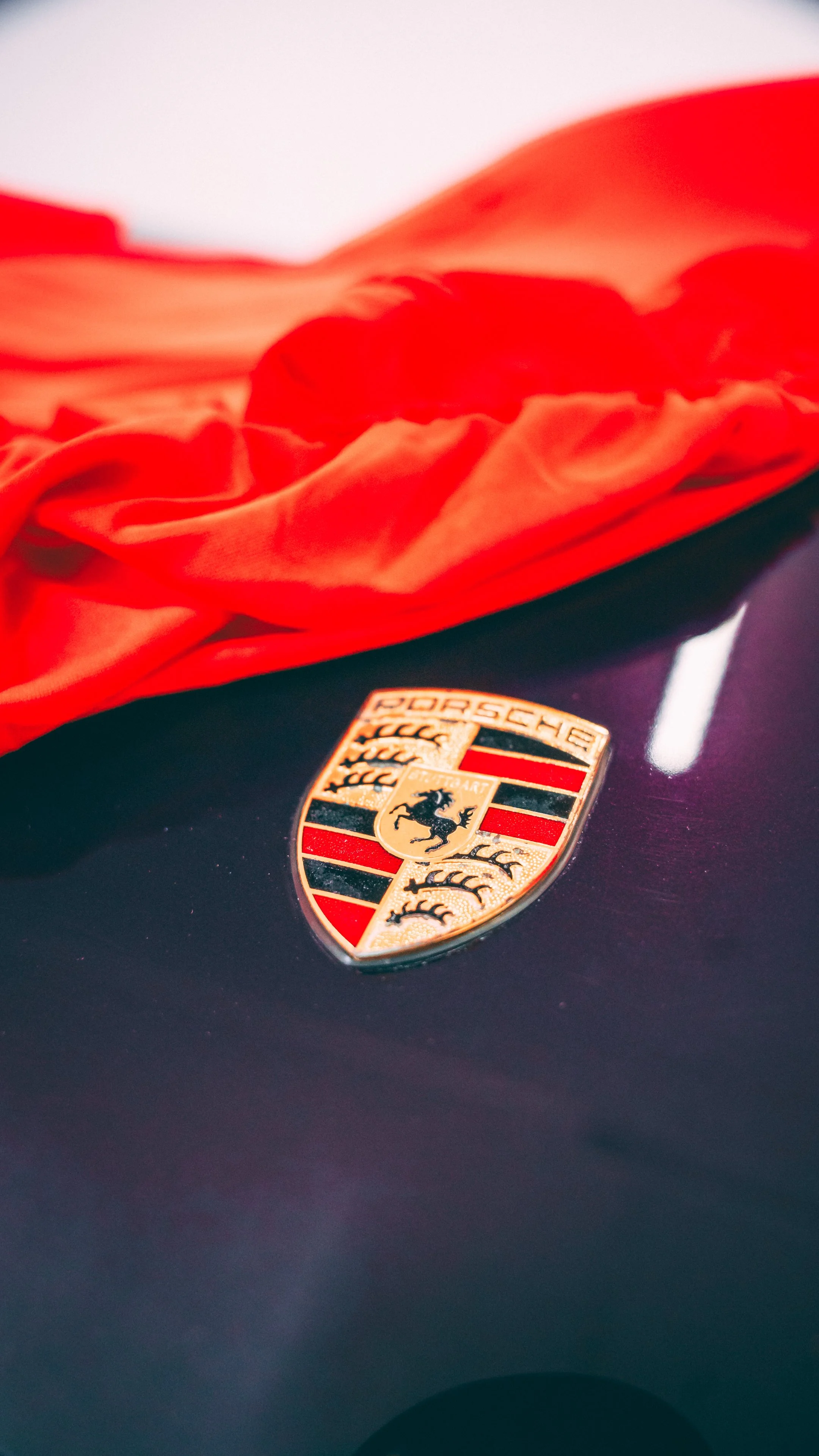 A Purple Porsche placed in storage with a red cover