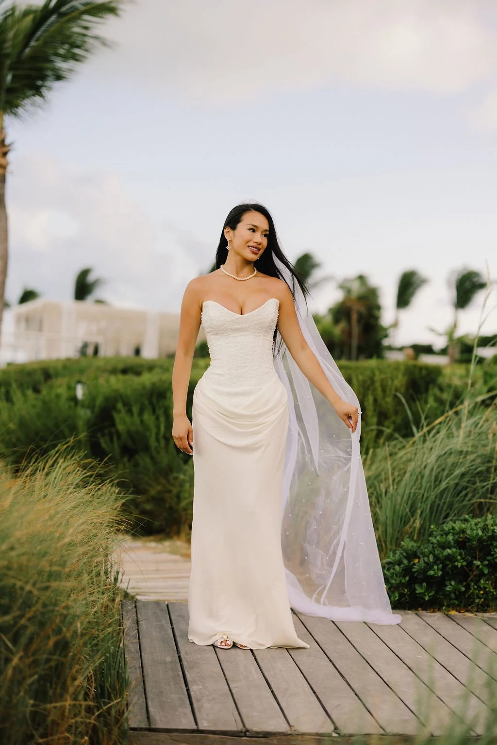 Natasha in her wedding dress on the boardwalk beside Long Bay Beach.