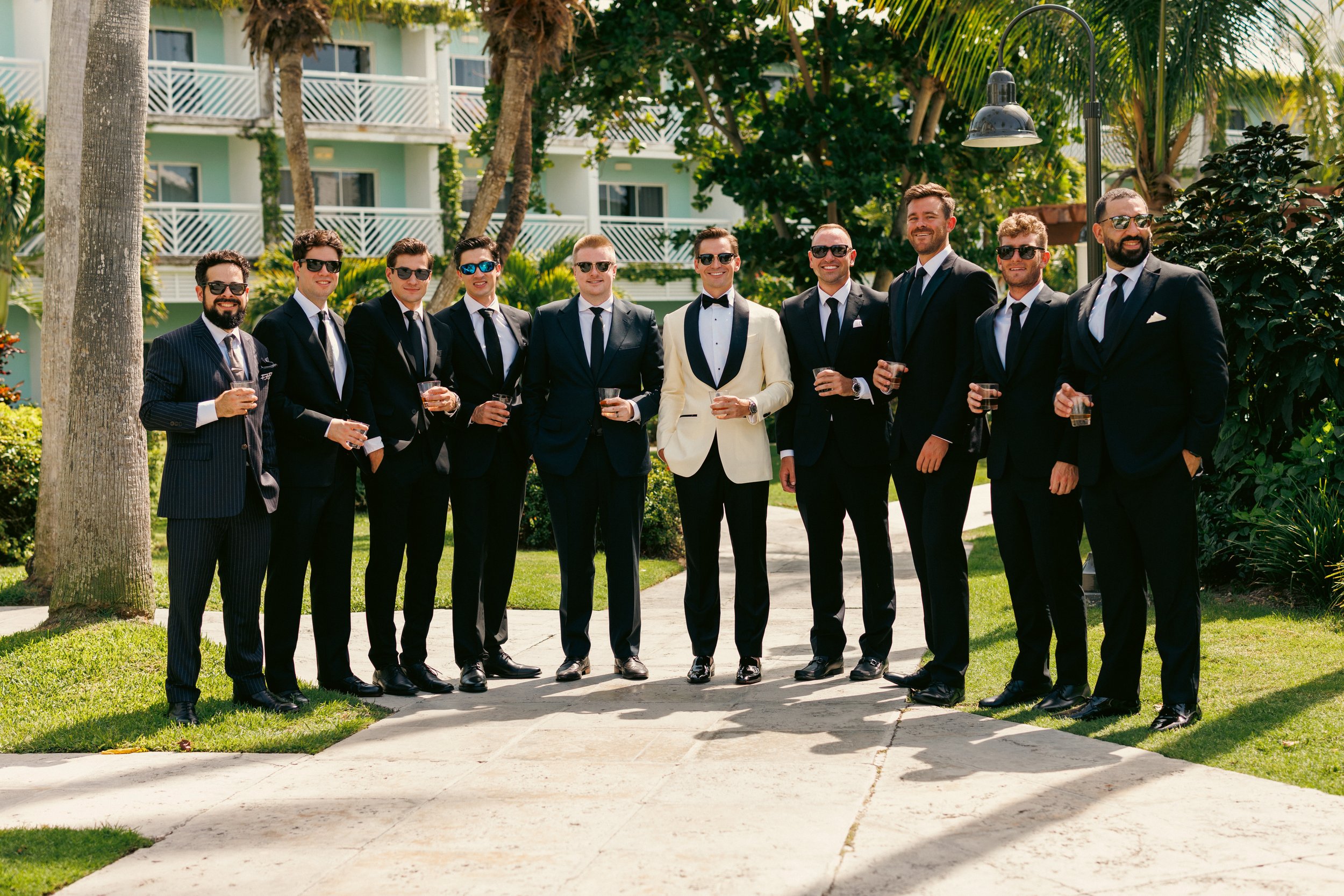 Kyle and his groomsmen posing along a palm lined walkway at Beaches Turks and Caicos