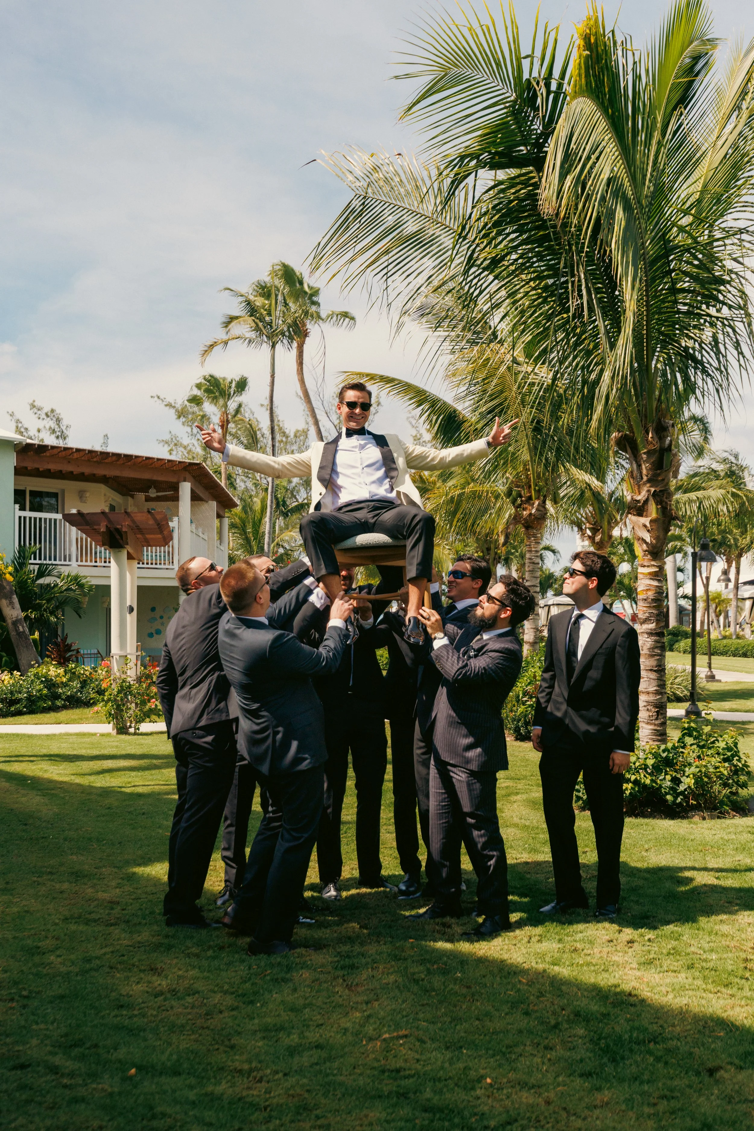 Kyle lifted in a chair by his groomsmen on the lawn at Beaches Turks and Caicos