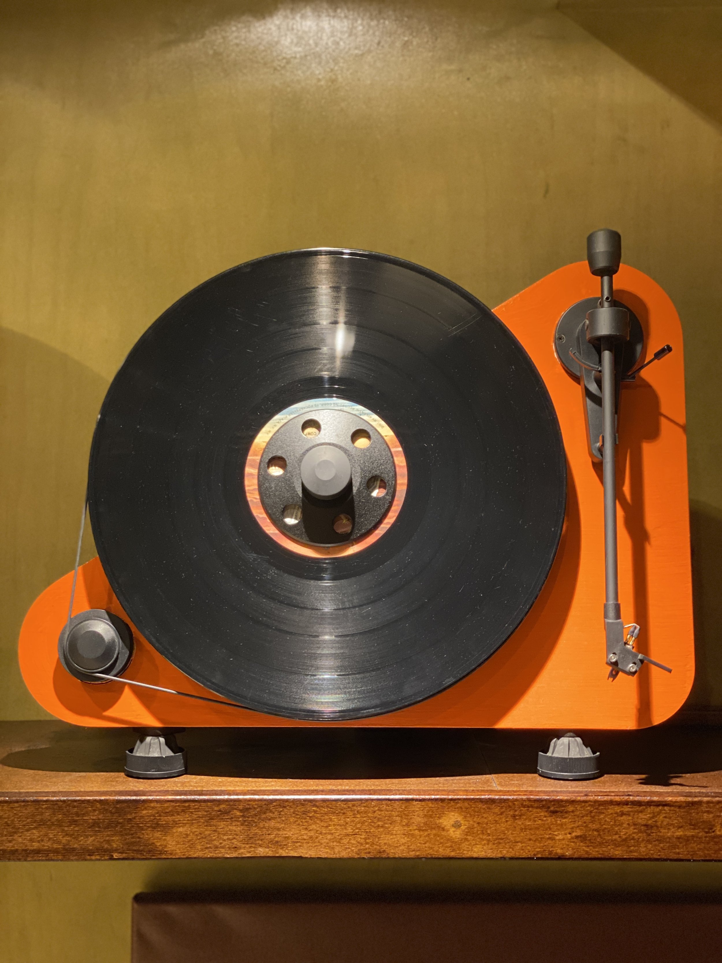 Pro-Ject VT-E vertical turntable... I painted it the exact same orange as my Dad's front door used to be.  Despite appearances, this is not a “gimmicky” turntable--it’s actually very well regarded and puts out incredible sound!