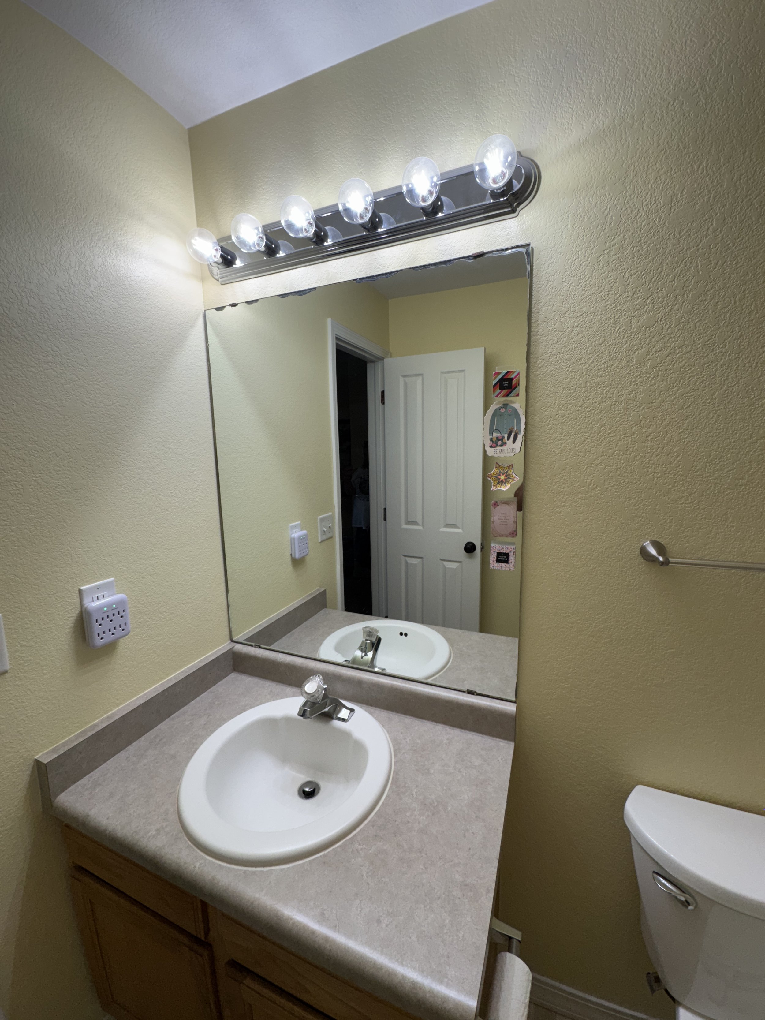 Different view of the tired old sink, mirror, and lighting.