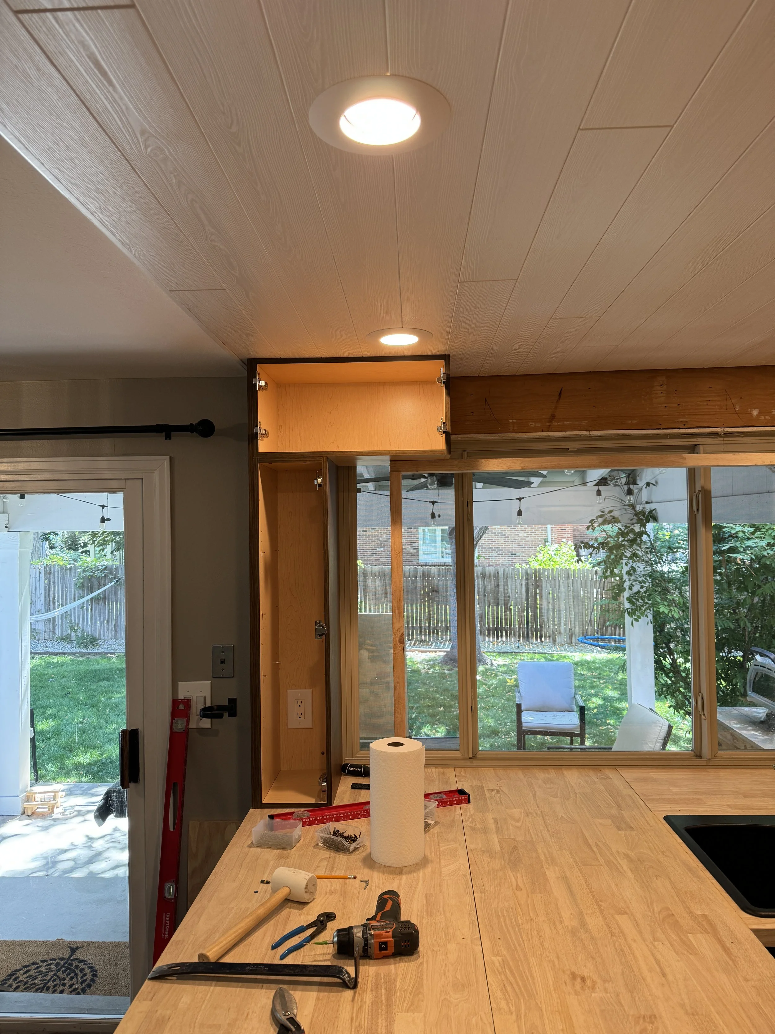 Installing the high cabinets to frame the window.  This was easy, since I was screwing them directly to the window header--so no stud finder needed!  (And I can't use one of those anyway, it goes haywire when I hold it... DAD JOKE!  LOL)