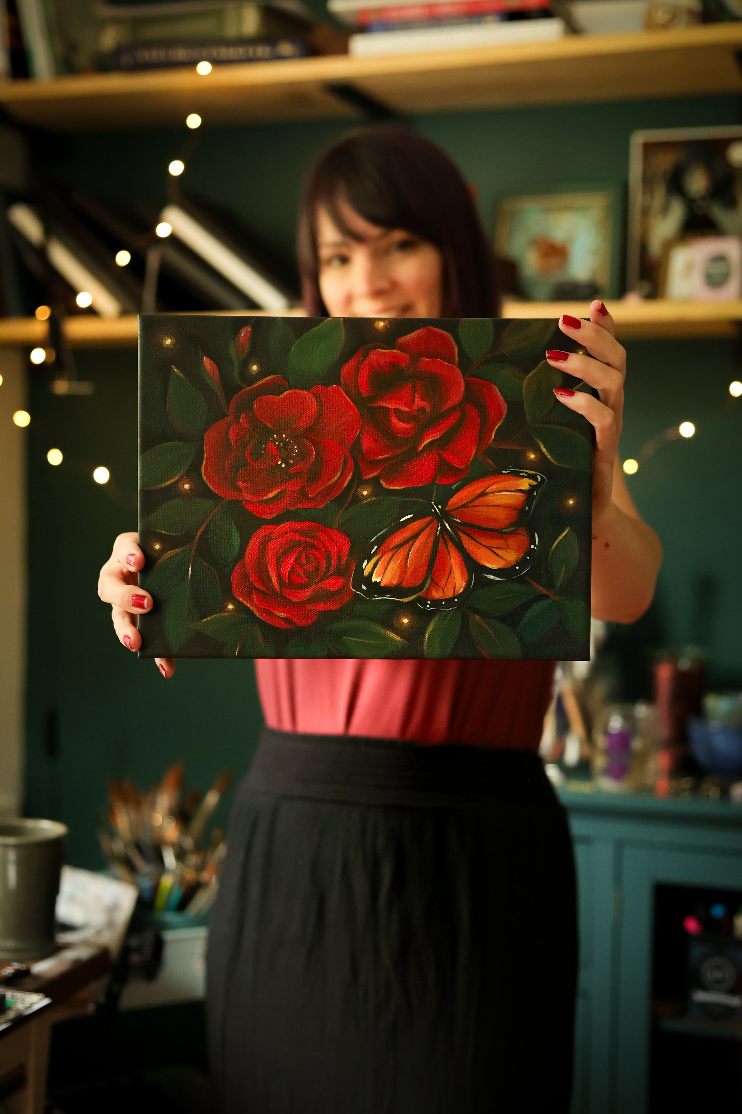 woman with painting of red roses and monarch butterfly