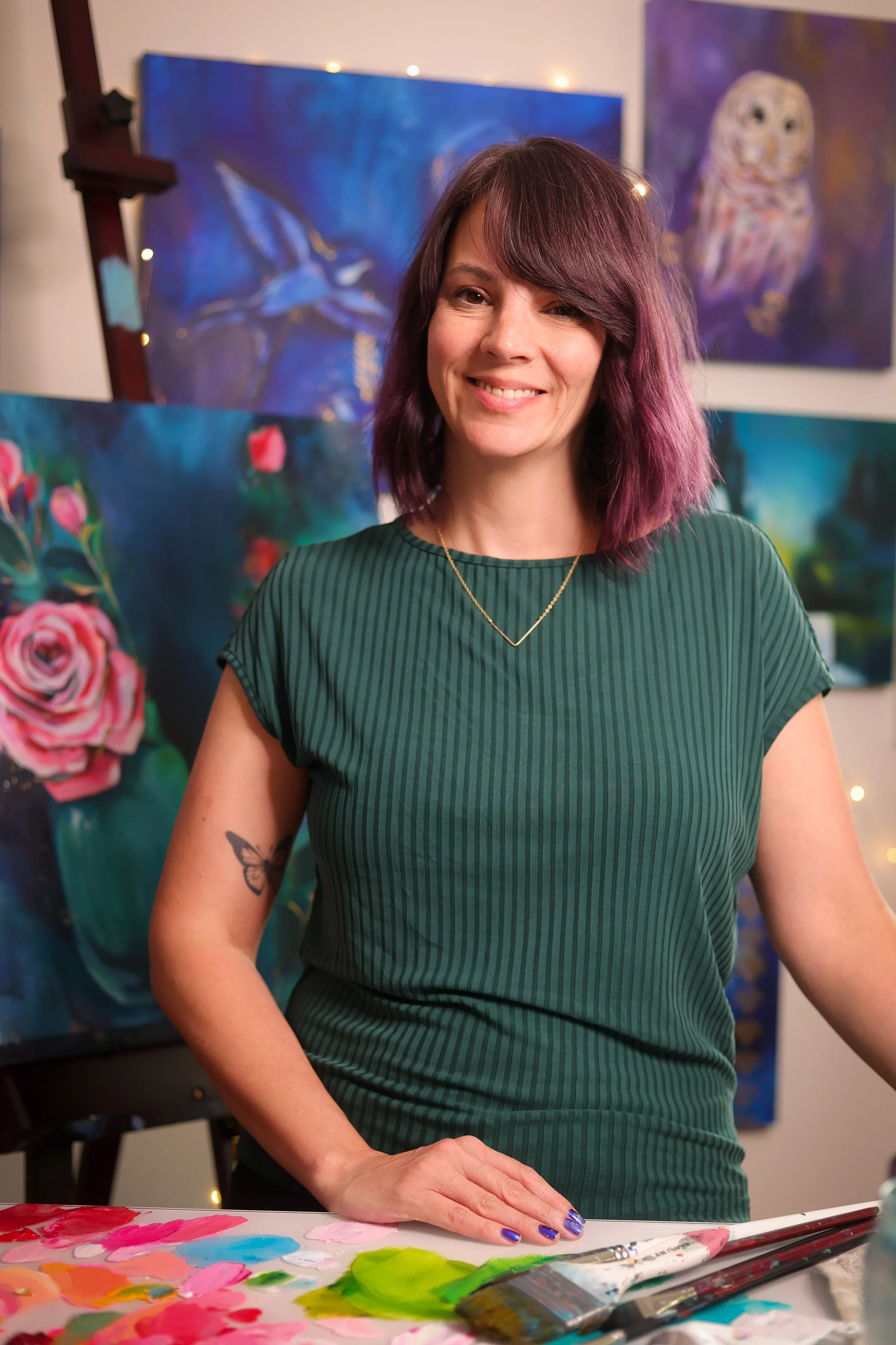 Maria Overlay Woman Artist smiling with colorful artwork behind her