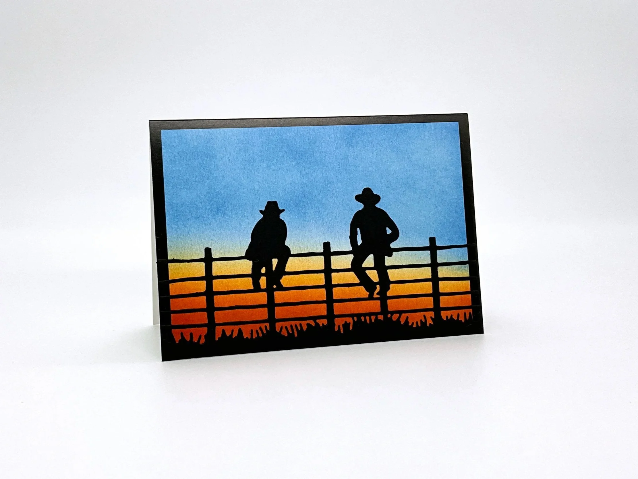 Station Hands sitting on fence at dusk