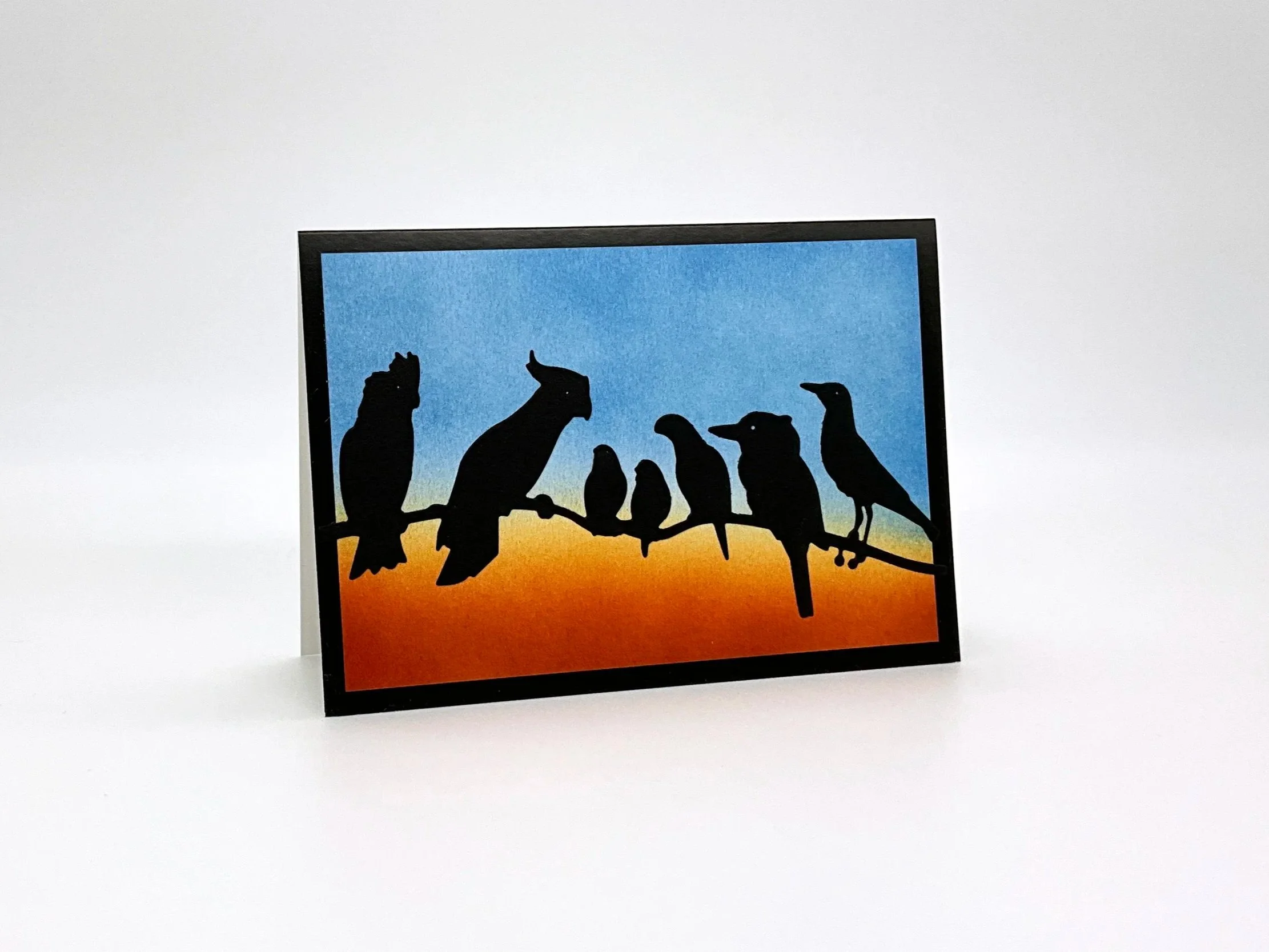 Seven birds on branch at dusk