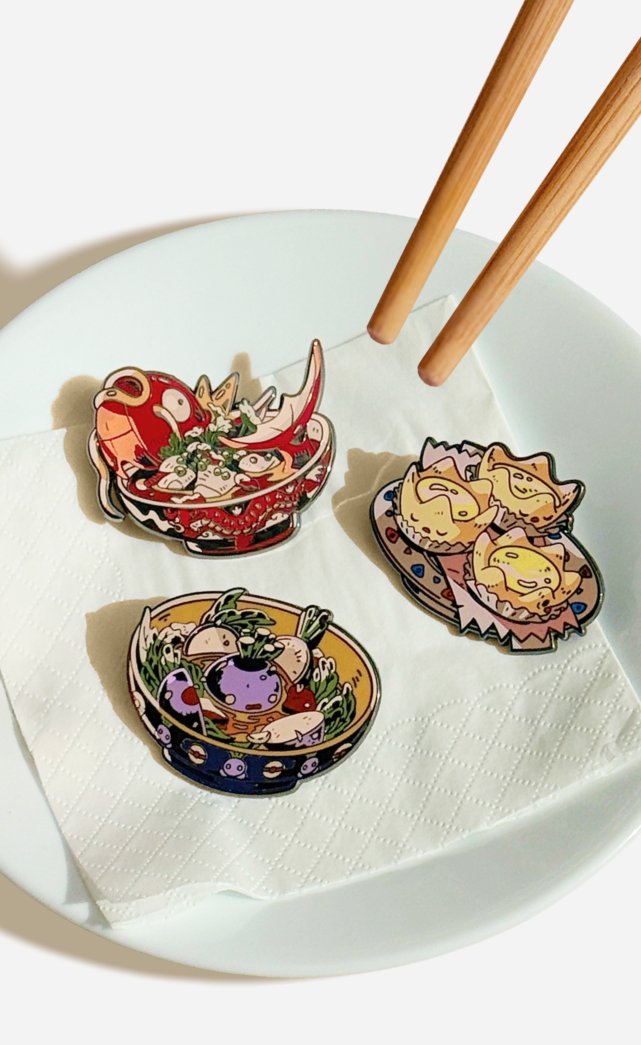 Pins of Pokémon as popular Chinese food dishes placed on a white plate with wooden chopsticks.