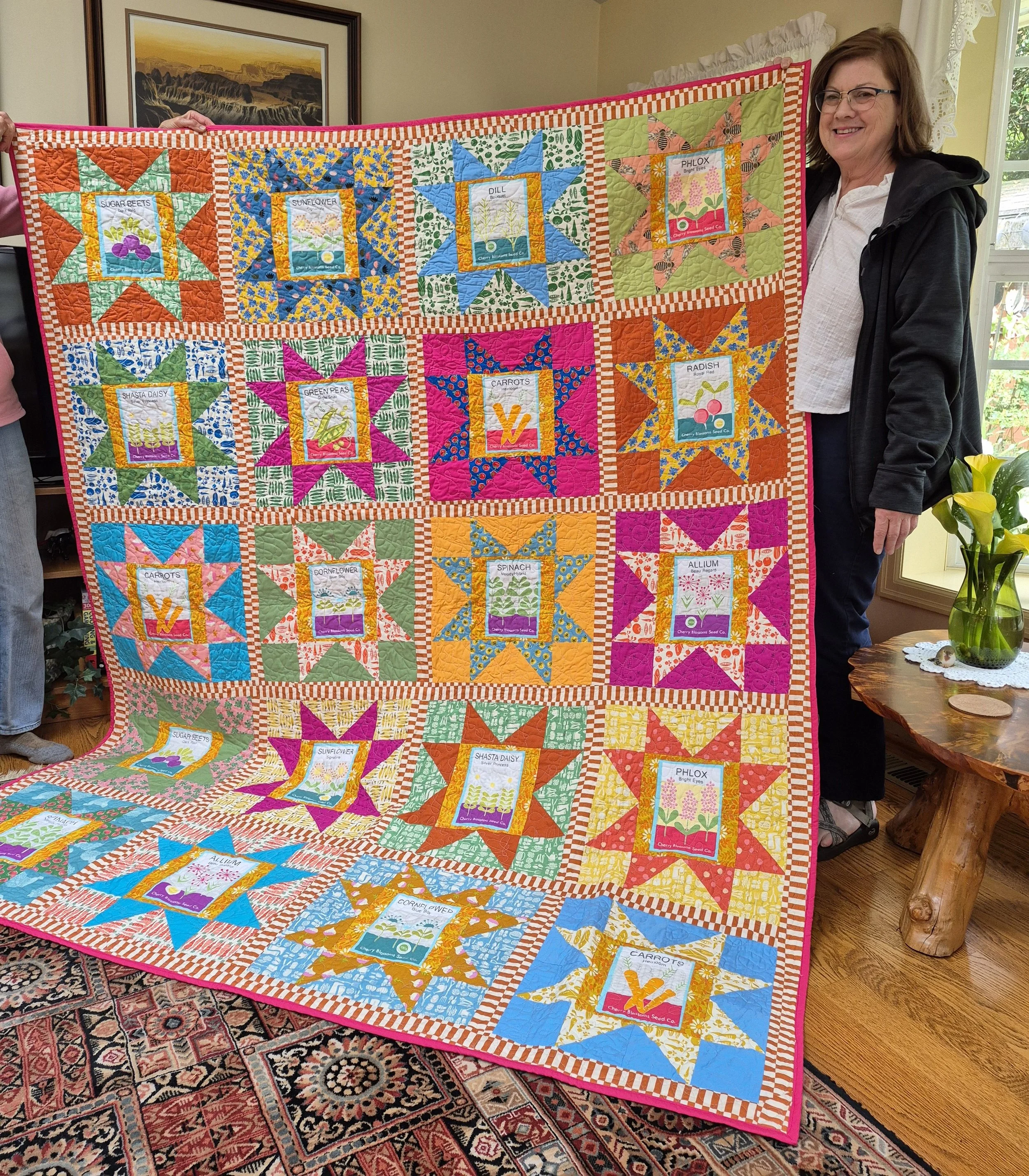 image of a woman holding a quilt with bright colors