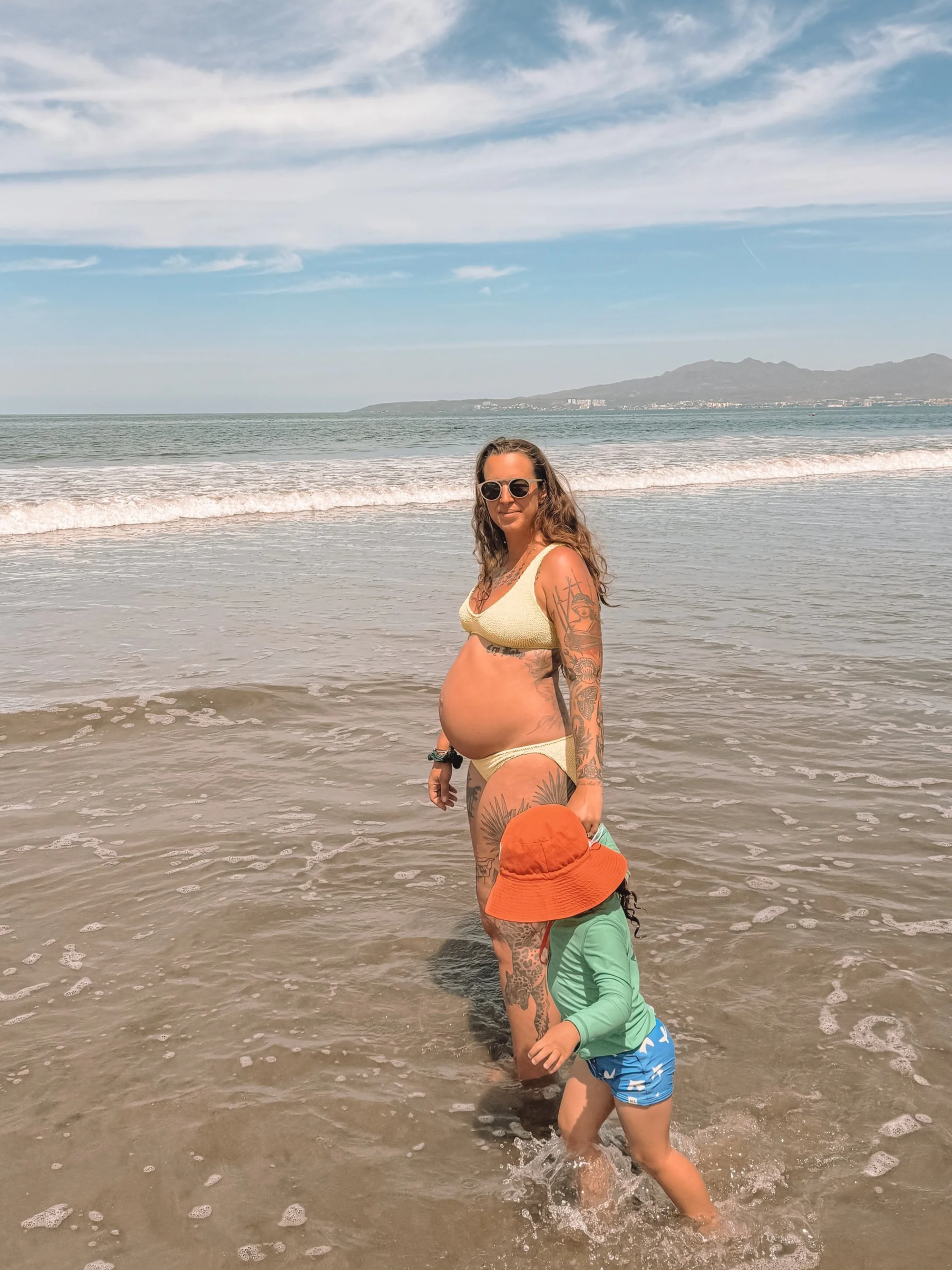 pregnant doula at the beach with her toddler