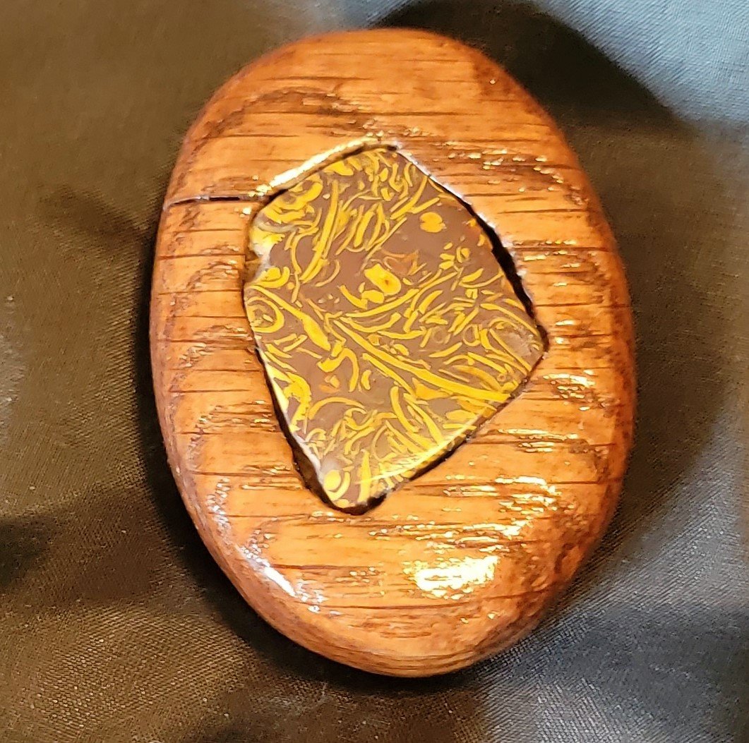 Decorative chocolate with yellow swirl pattern on a wooden slab