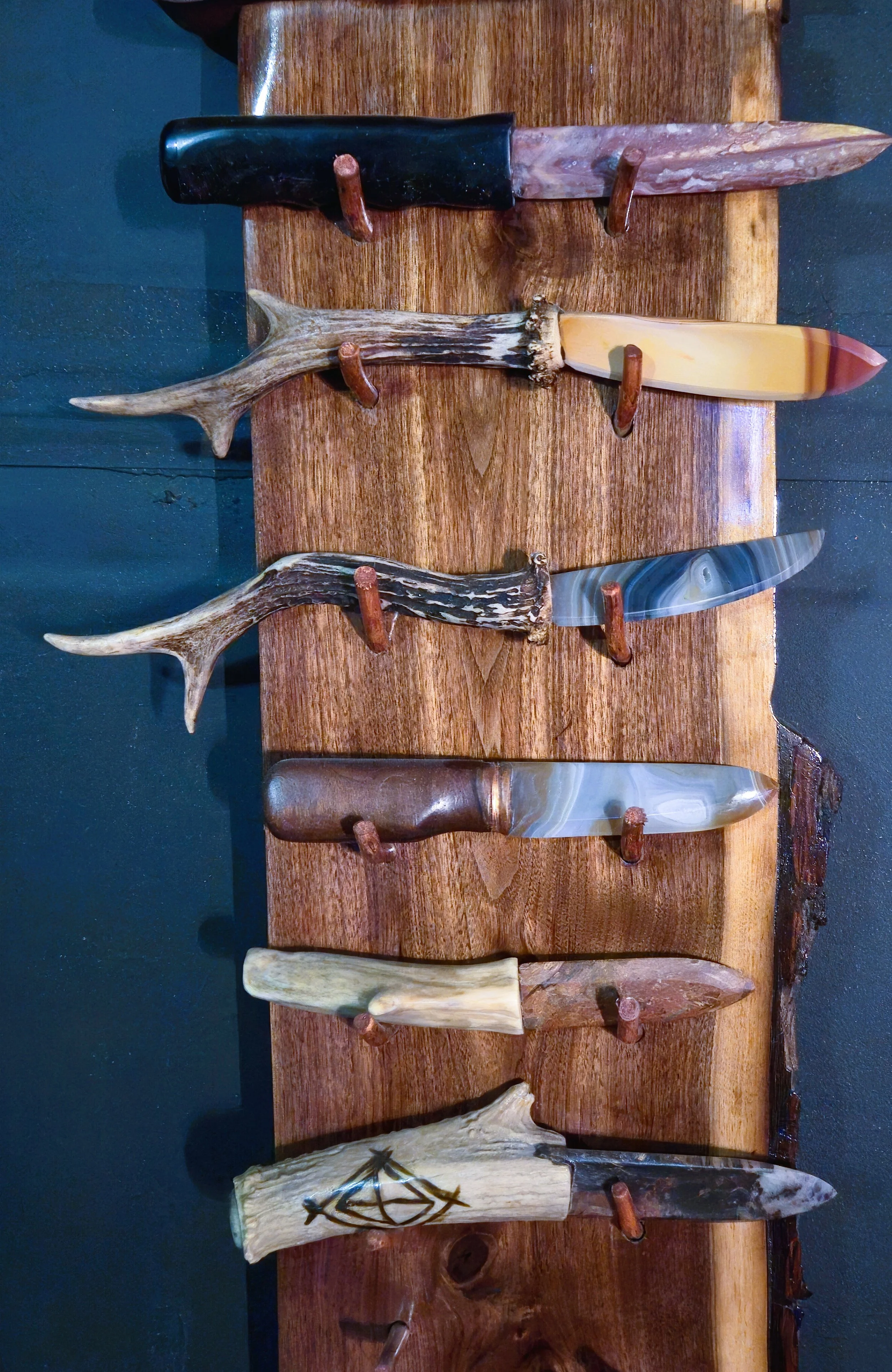 Display of various carved and polished animal horns and antlers on a wooden table.