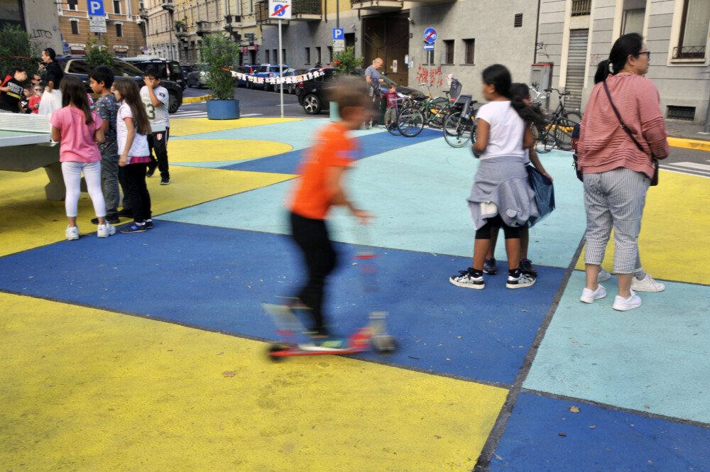 Children play on a colorfully painted street plaza