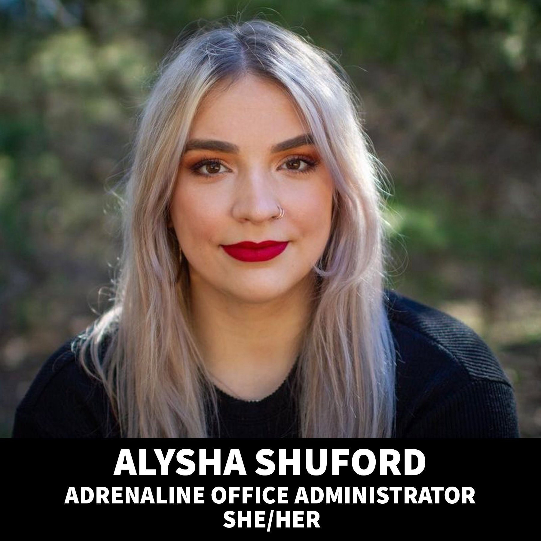 Portrait of Alysha Johnson, an office administrator with blonde hair, wearing a black top, red lipstick, and a nose ring, outdoors with blurred greenery in the background. Her name and title are displayed at the bottom of the image.