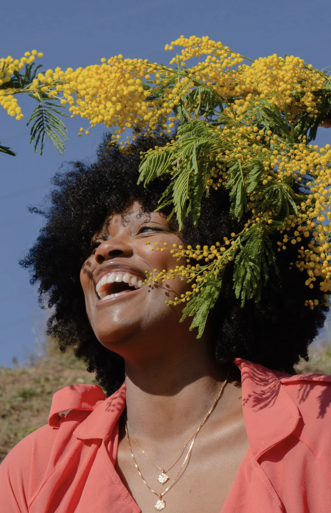 Woman laughing with flowers around her