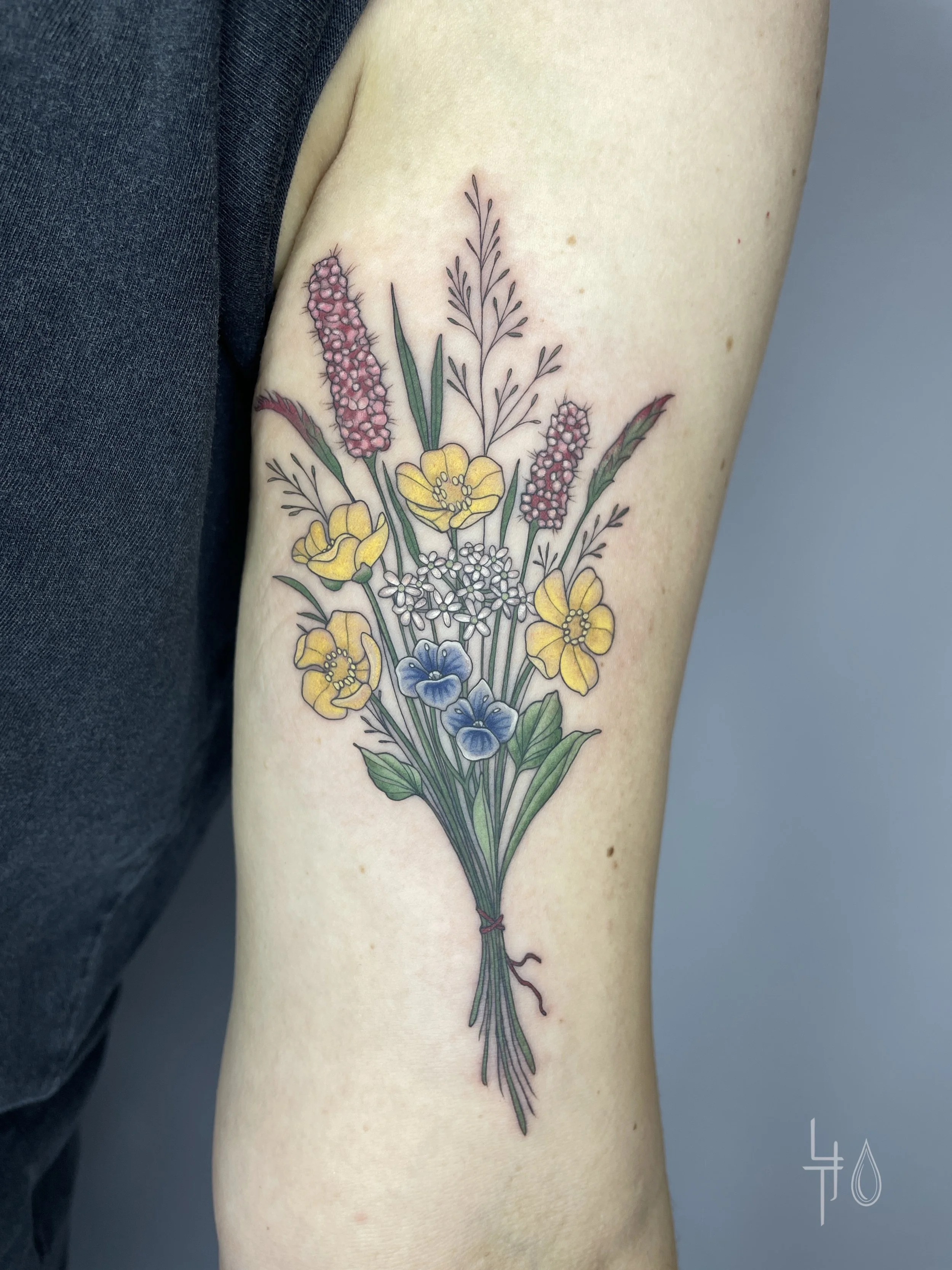 Farbiges Tattoo von Trockenblumen am Arm