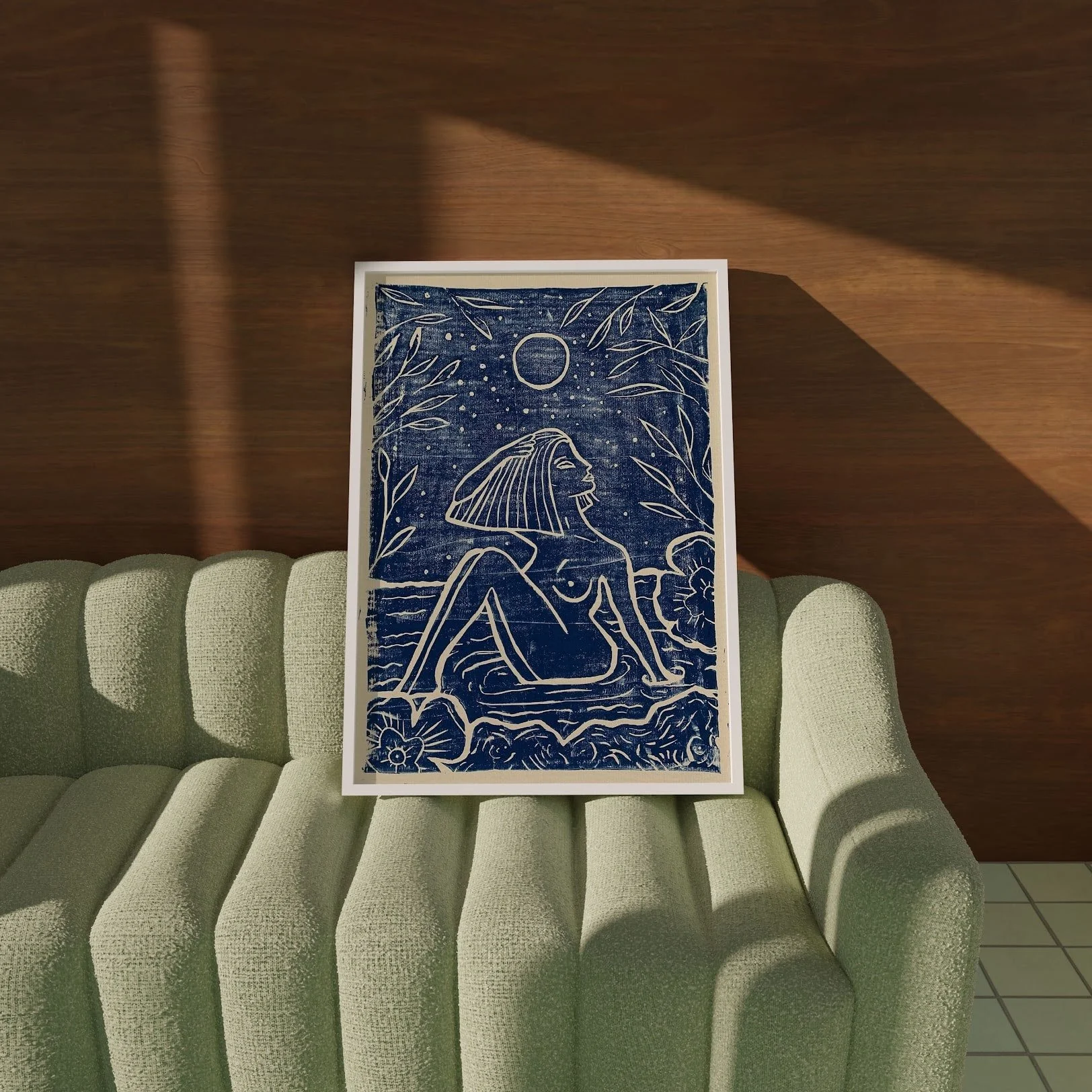 Der Linoldruck Mitternachtsbad ist eingerahmt und steht auf einem hellgrünen Sofa. Er stellt eine nackte Frau dar, die bei Vollmond badet. Der Linolprint ist einfarbig in Indigoblau.