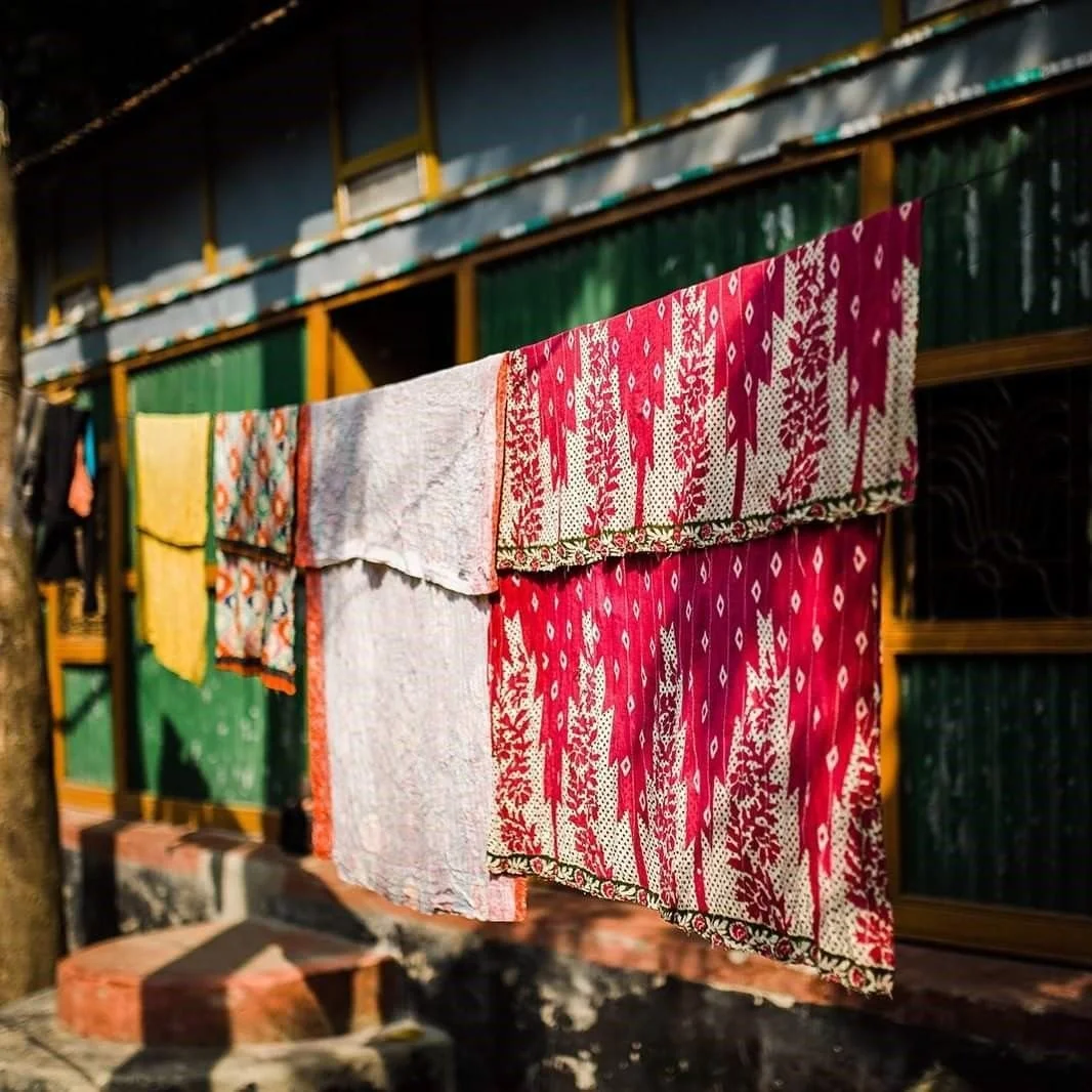 Kanthas drying in the sun, preparing for their journey to the UK..❤️

Our kantha honours ancient traditions, using layer upon layer of softest, time worn saris, meticulously hand stitched together with close rows of kantha running stitch. Each kantha