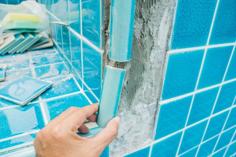 Pool tiles being repaired by Frank N Pools