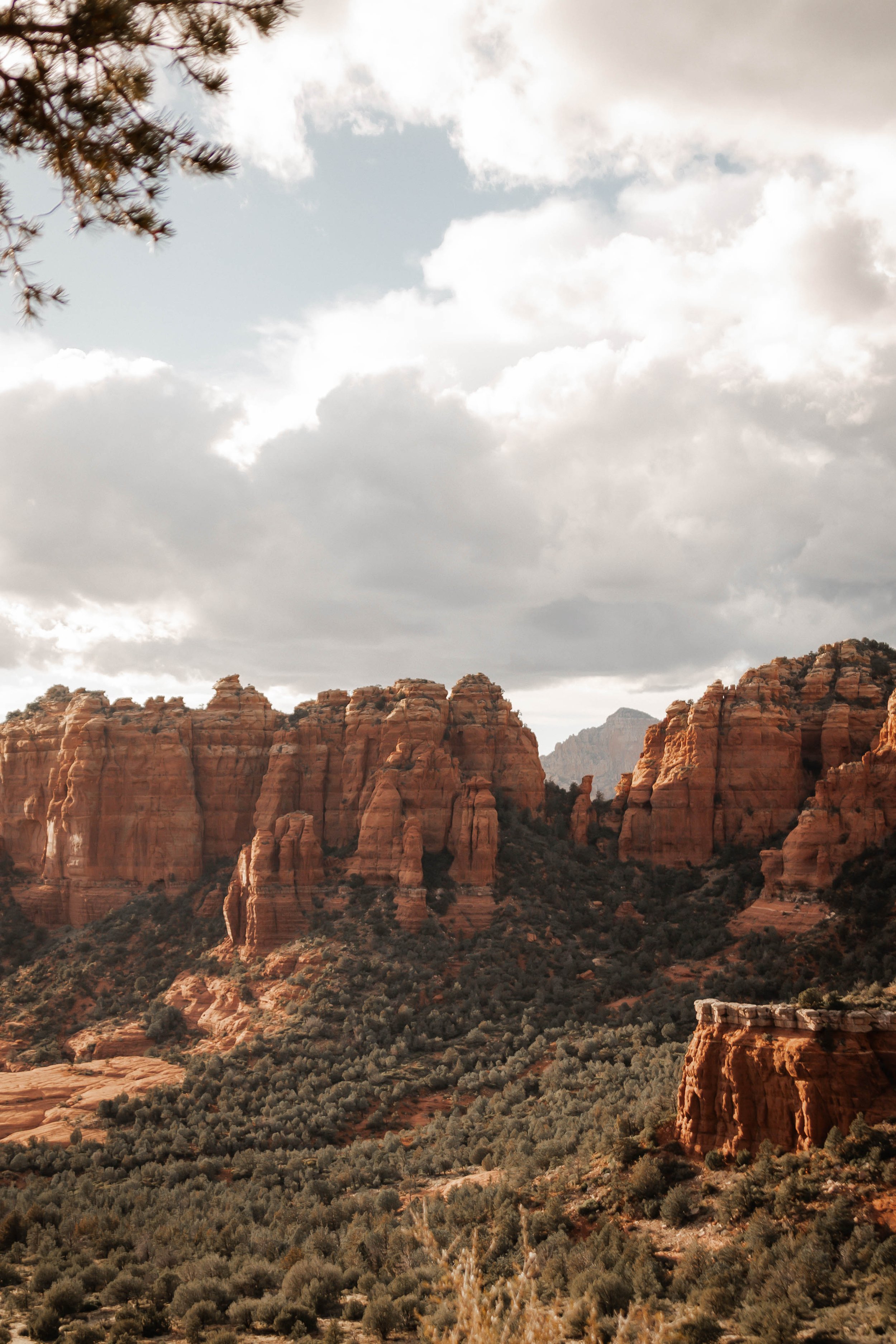Scenic view of red rock formations and cliffs in Bear Wallow Valley Sedona, Arizona under cloudy sky