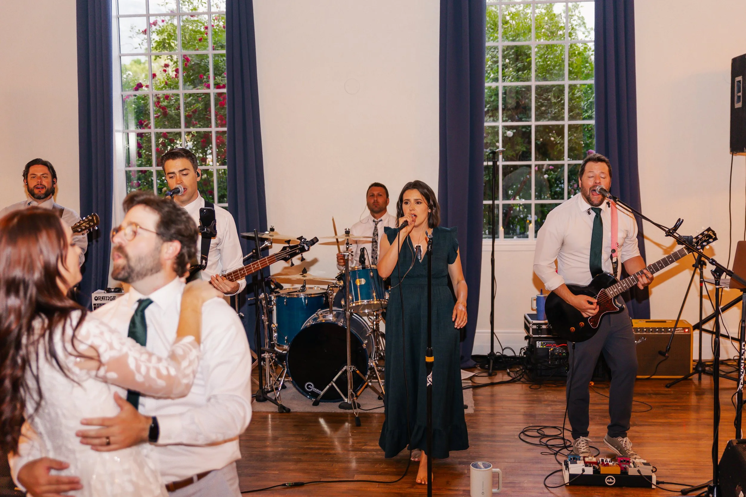 Band performing at a wedding reception, with a couple dancing in the foreground.