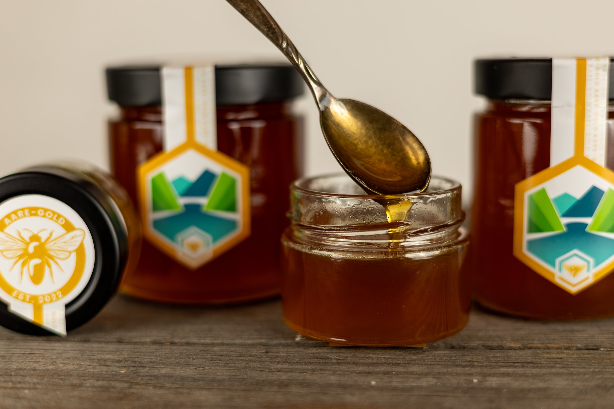 Schweizer Honig AARE GOLD im Glas, Honig tropft vom Löffel