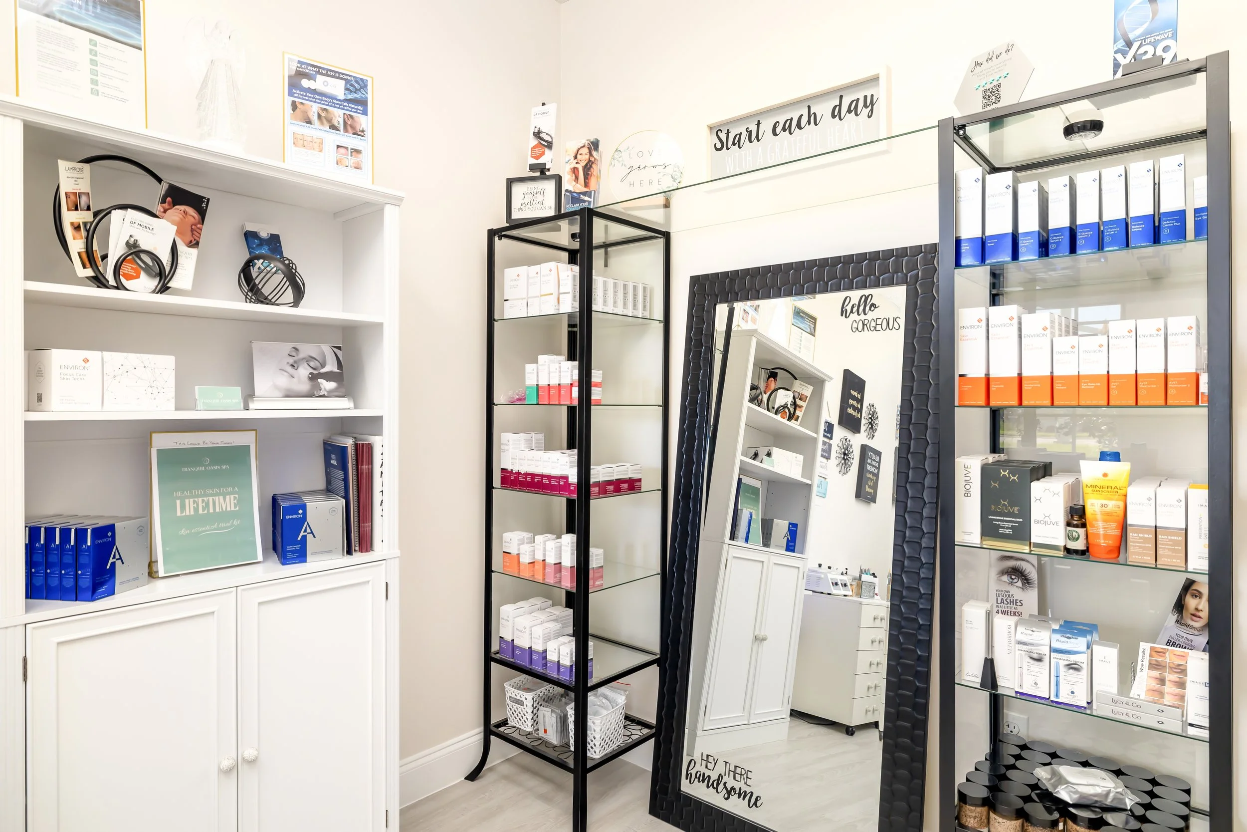 Interior of a beauty or skincare store with white and black shelving units displaying various skincare products. Bradenton Spa