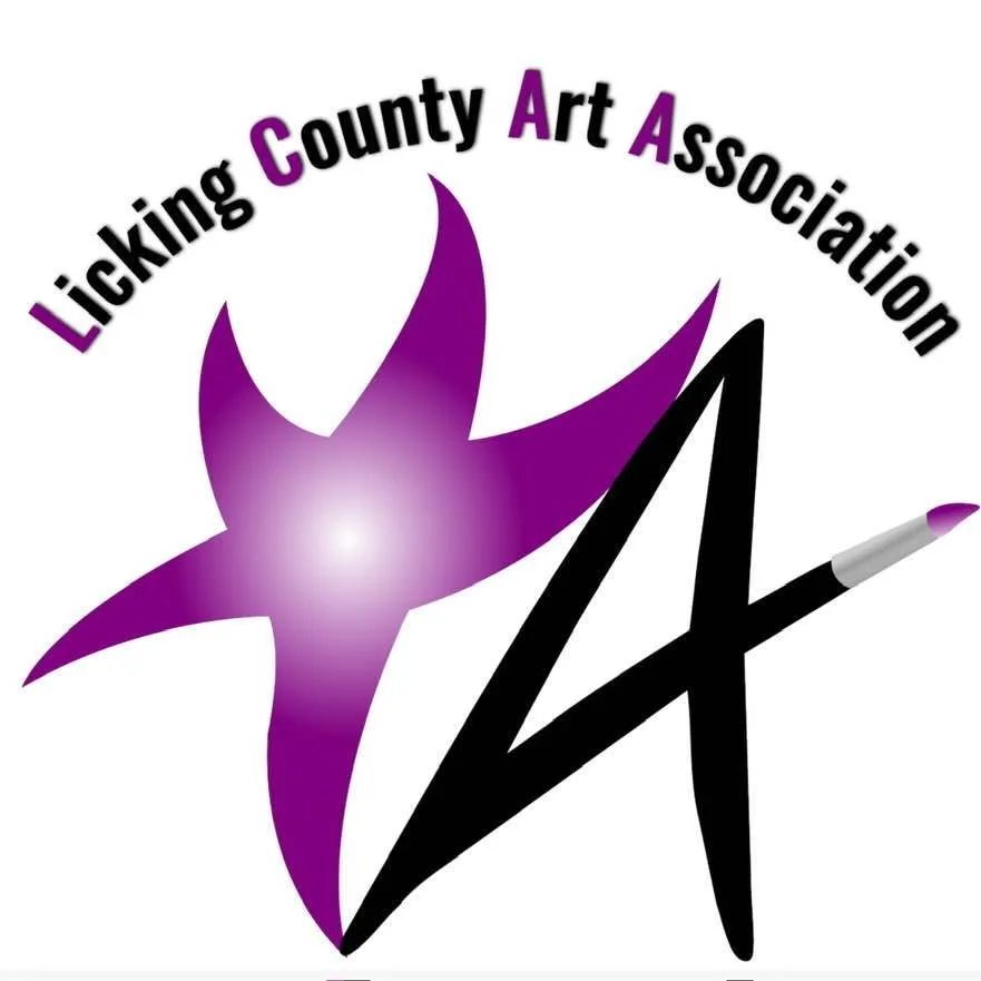 Sign for Licking County Art Association with framed artwork in the background.