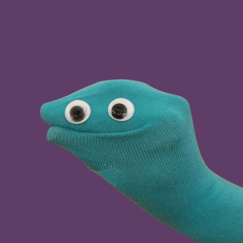 A teal sock with two googly eyes attached, resembling a face, against a purple background.