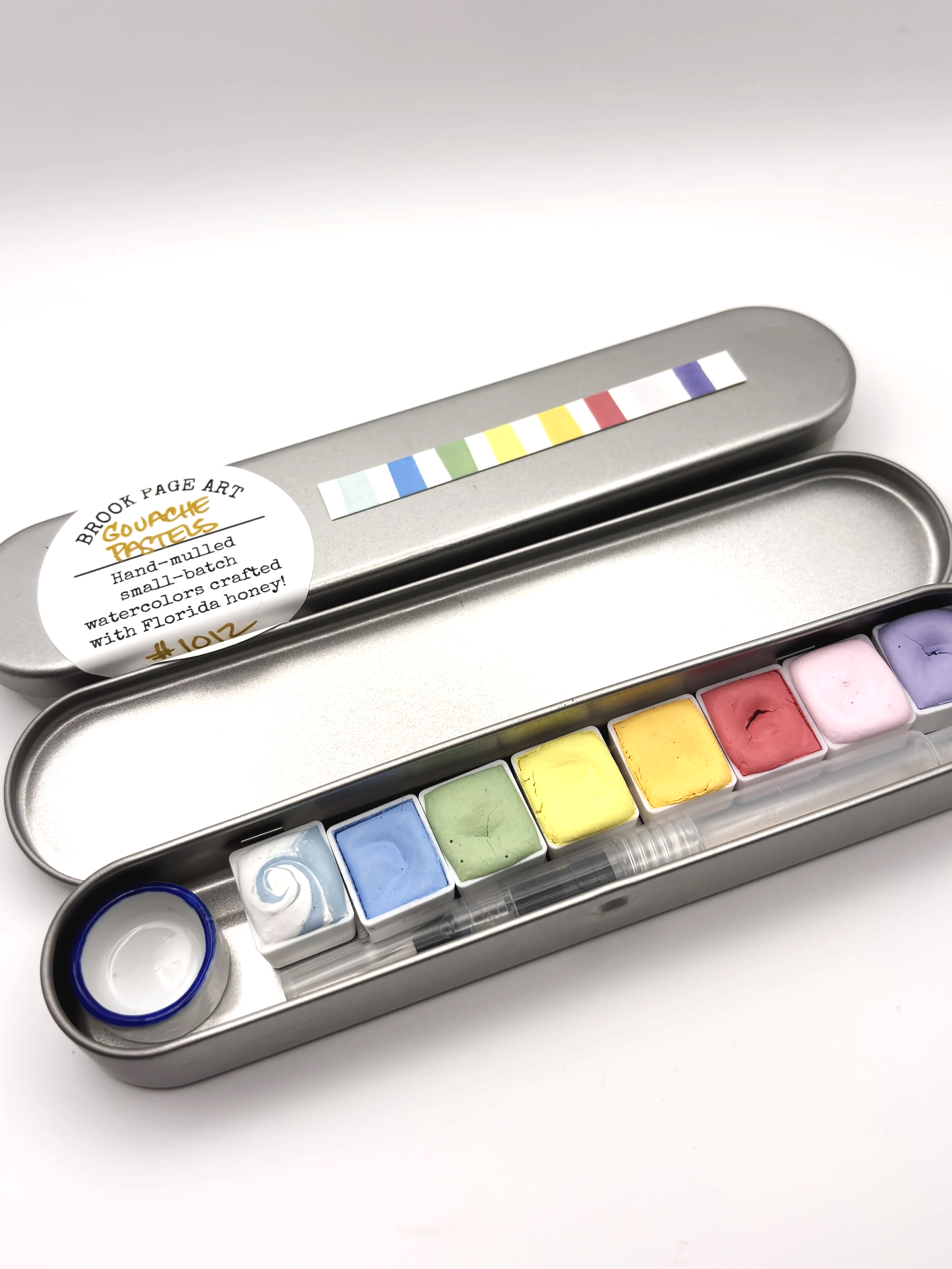 Eight handmade creamy pastel gouache paints in a travel tin, hand-mulled with pigments local Florida honey by Artist, Brook Page