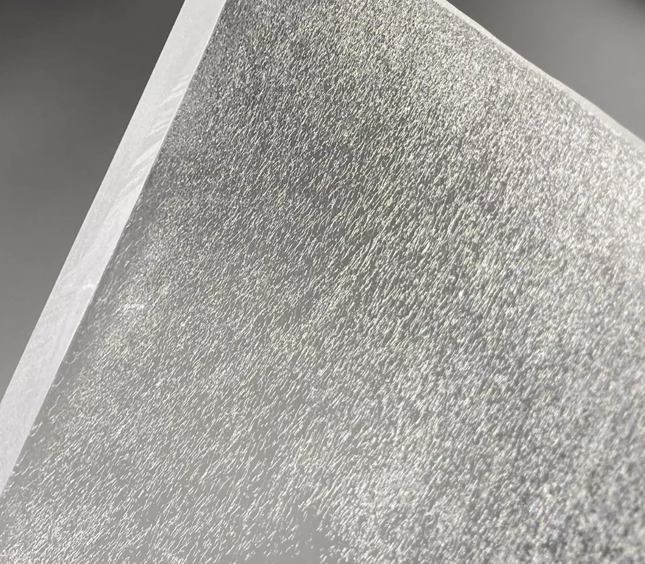 Close-up of a textured, metallic surface with a shimmering, reflective finish.