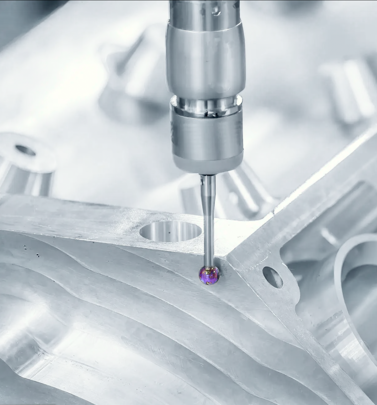 Close-up of a precision machine tool drilling engine component.