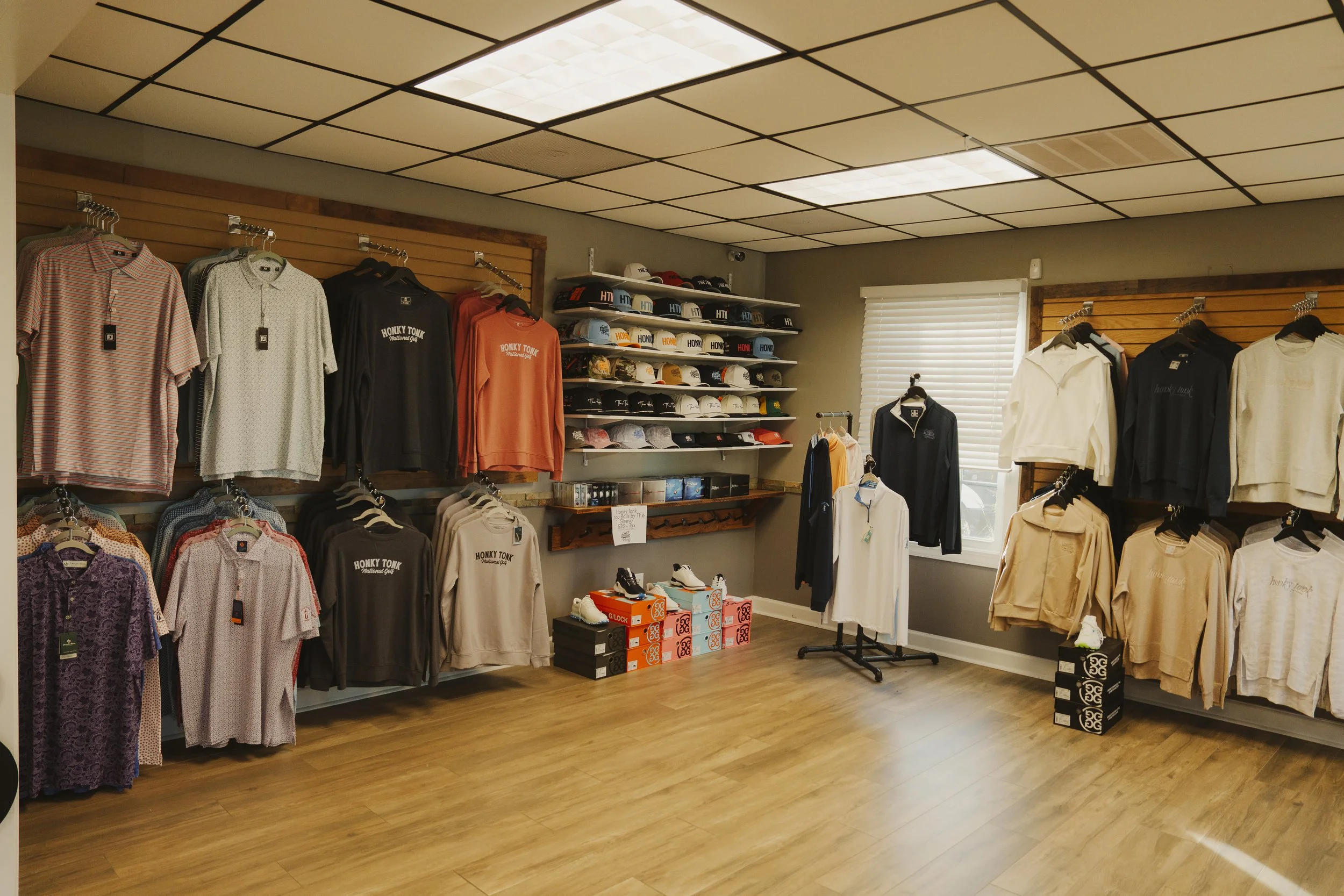 Display of men's polo shirts, hoodies, and caps in a golf apparel store.