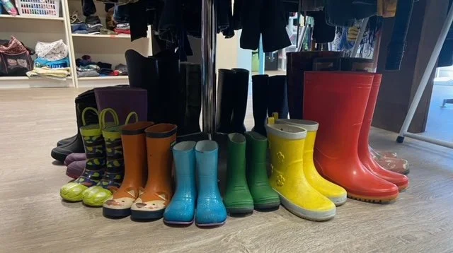 A bunch of pairs of rubber boots from children's to adult sizes.