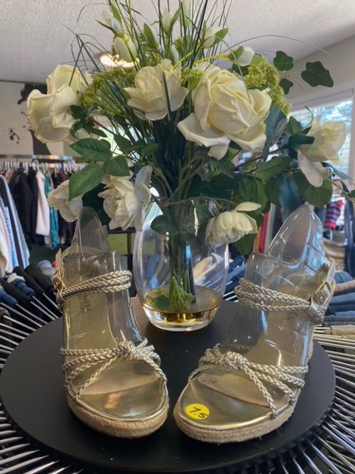 Vase of flowers next to a shiny pair of heels.