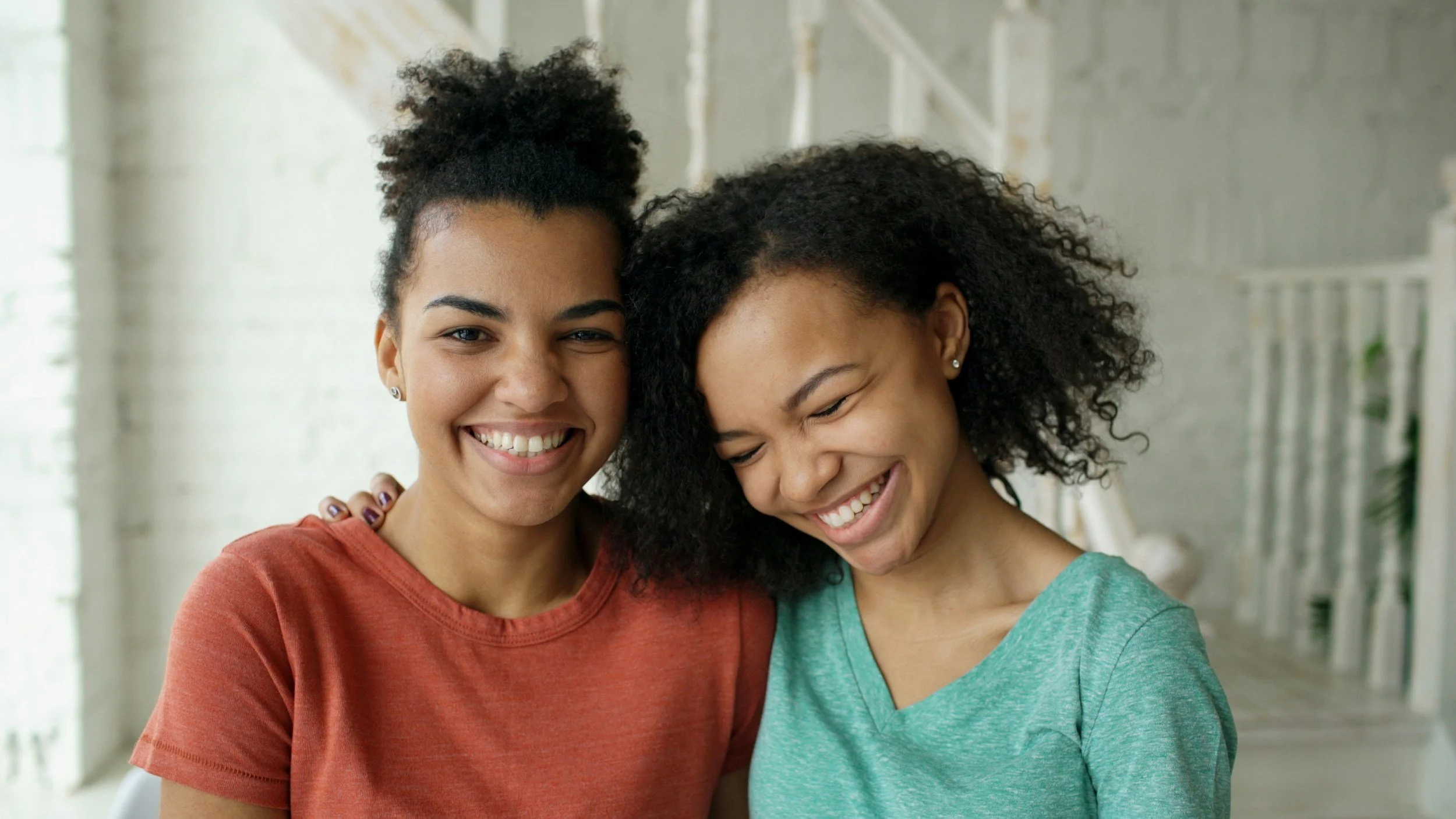 Two young women smiling together, representing peer connection and support through the Bright Futures program