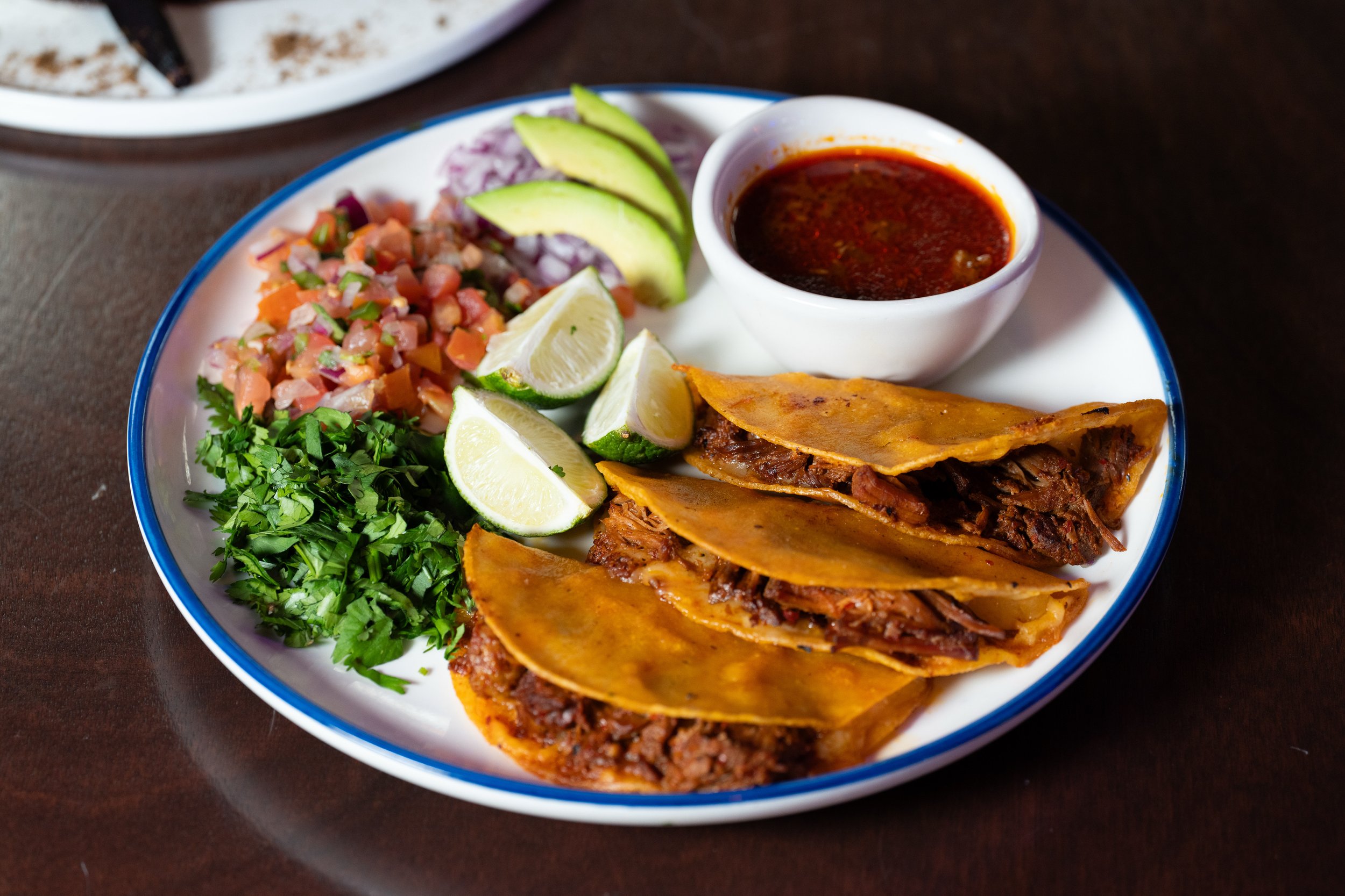 Quesabirria Tacos-
Three tacos made with homemade birria with melted cheese on your choice of corn or flour tortillas. Served with a side consomé for dipping.