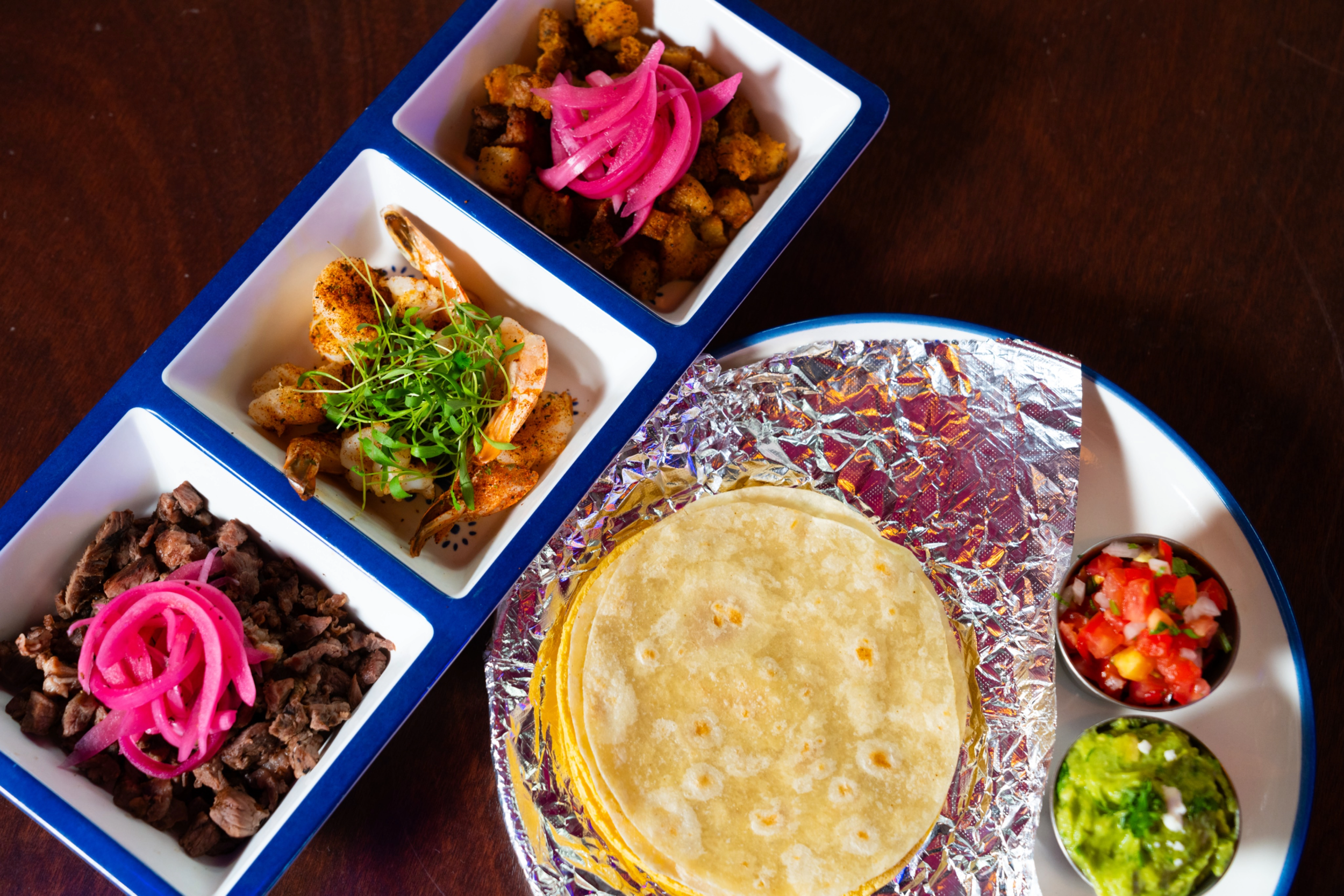 Trilogia De Tacos- Shareable build your own tacos. Six homemade tortillas, pico, guac, and your choice of any three of the following: Carne Asada, Grilled Shrimp, Pork Belly, Birria,
ribeye (extra charge) Roasted Mushrooms, Jackfruit Birria or Jamaic
