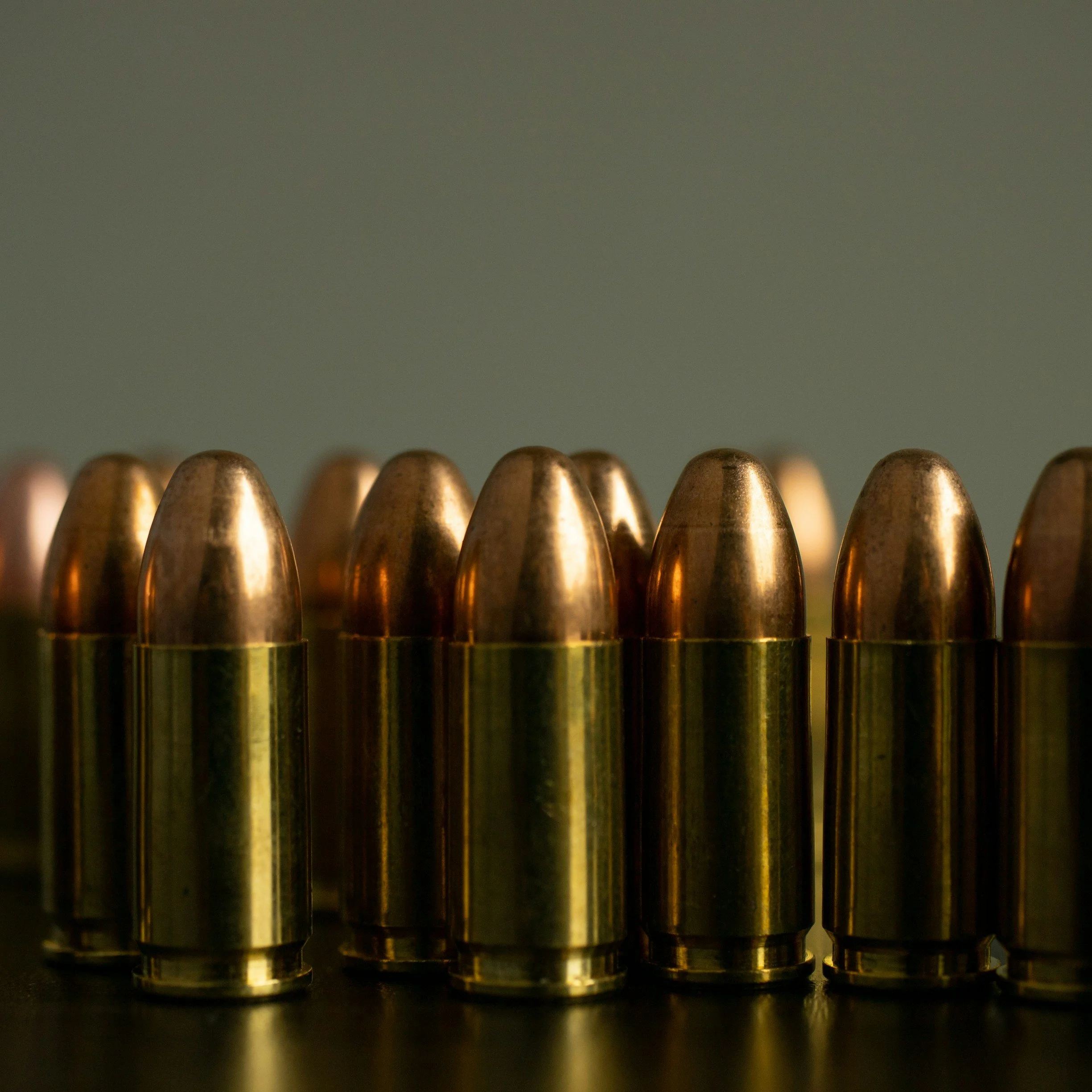 Close-up of several bullets standing upright on a surface.
