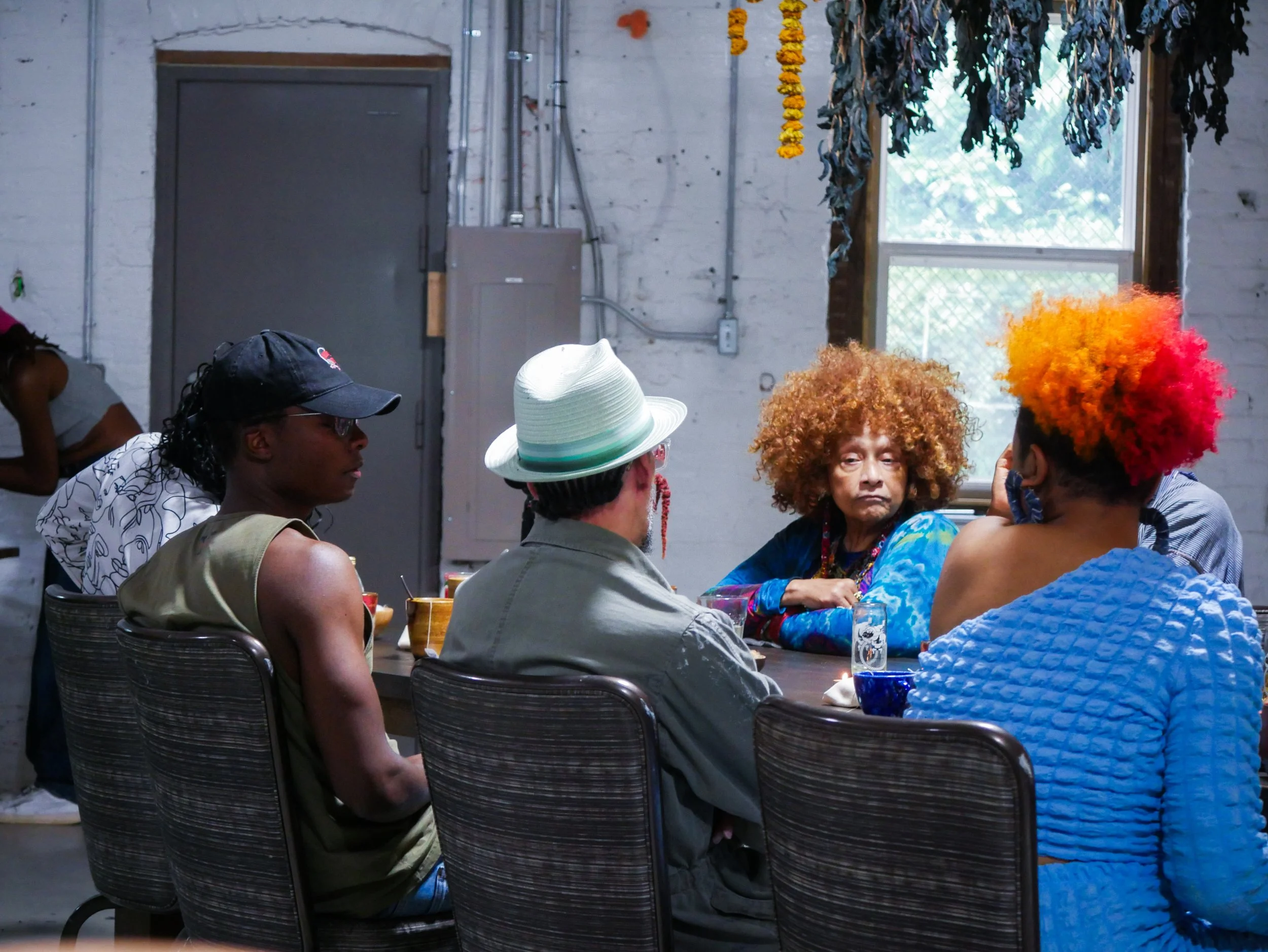 Participants gather around the table during a Mixing Bowl conversation centered on storytelling and creative exchange.