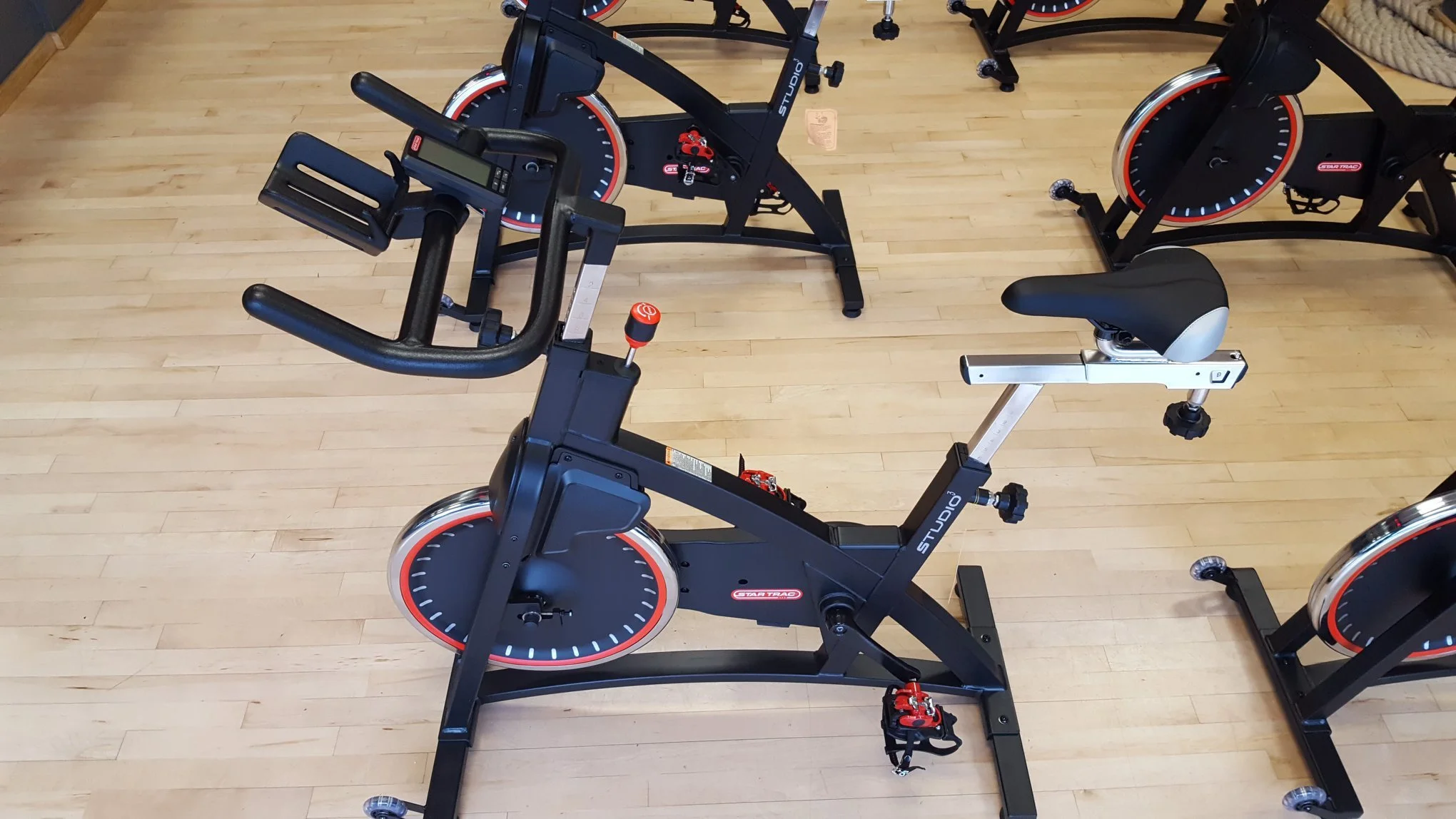 Indoor exercise bikes on a wooden floor.