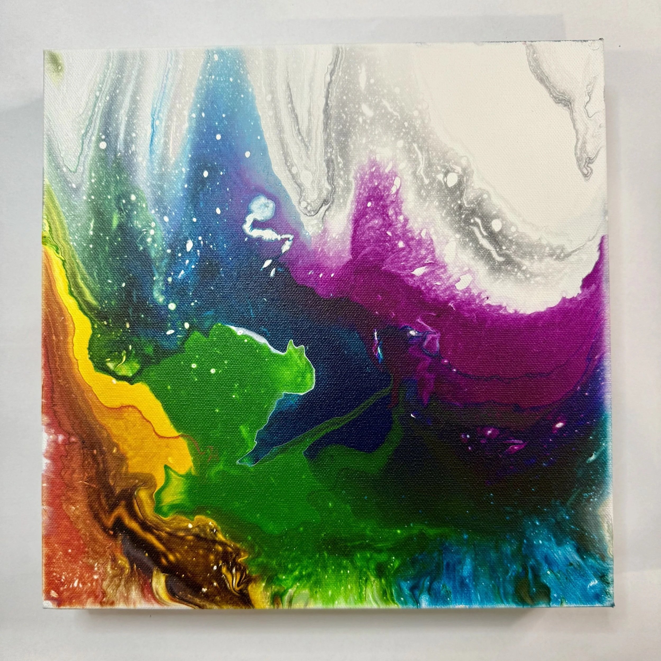 Colorful abstract painting with swirls of purple, green, blue, yellow, brown, and black, featuring white specks and fluid patterns.