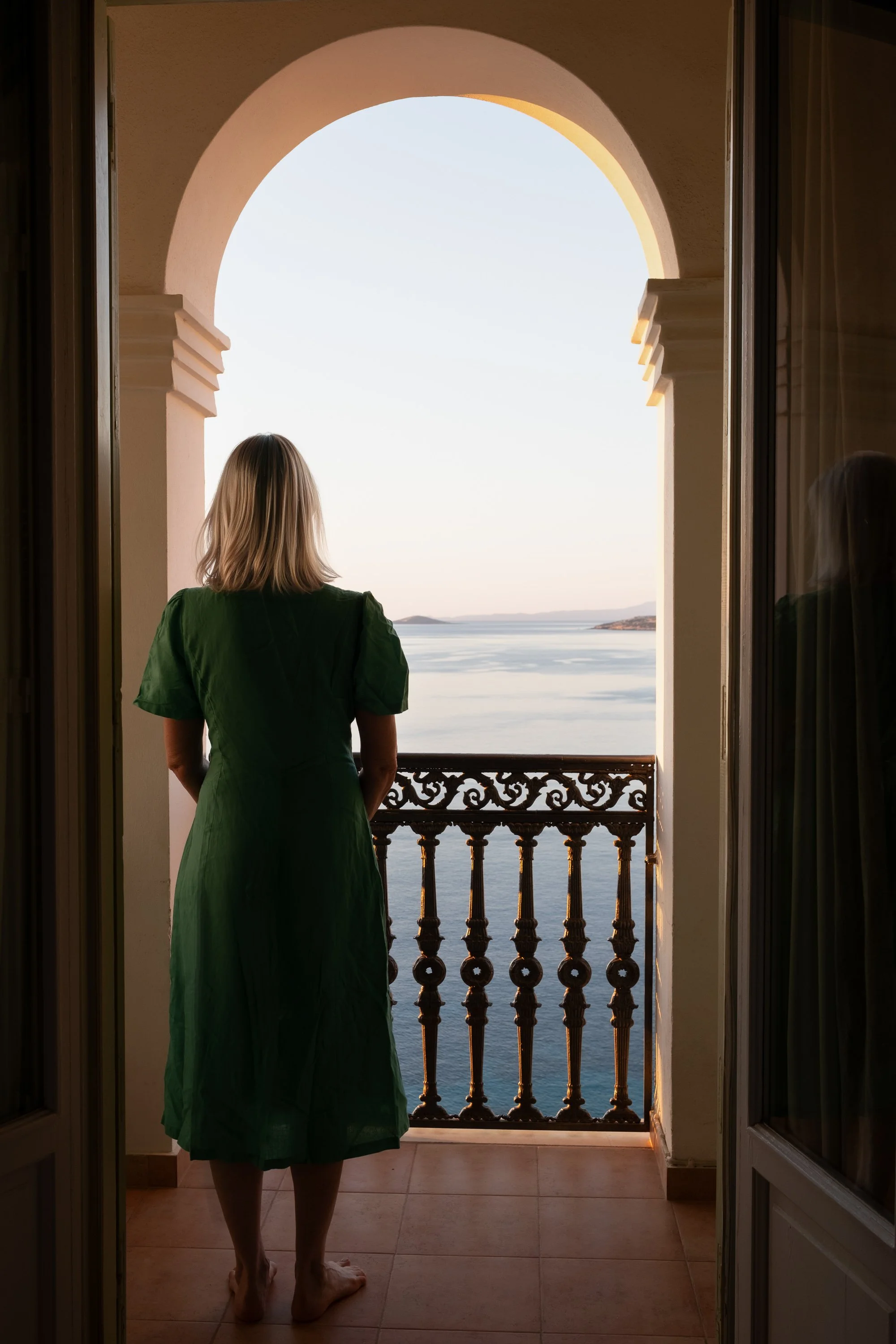 Woman in green dress overlooking the sea