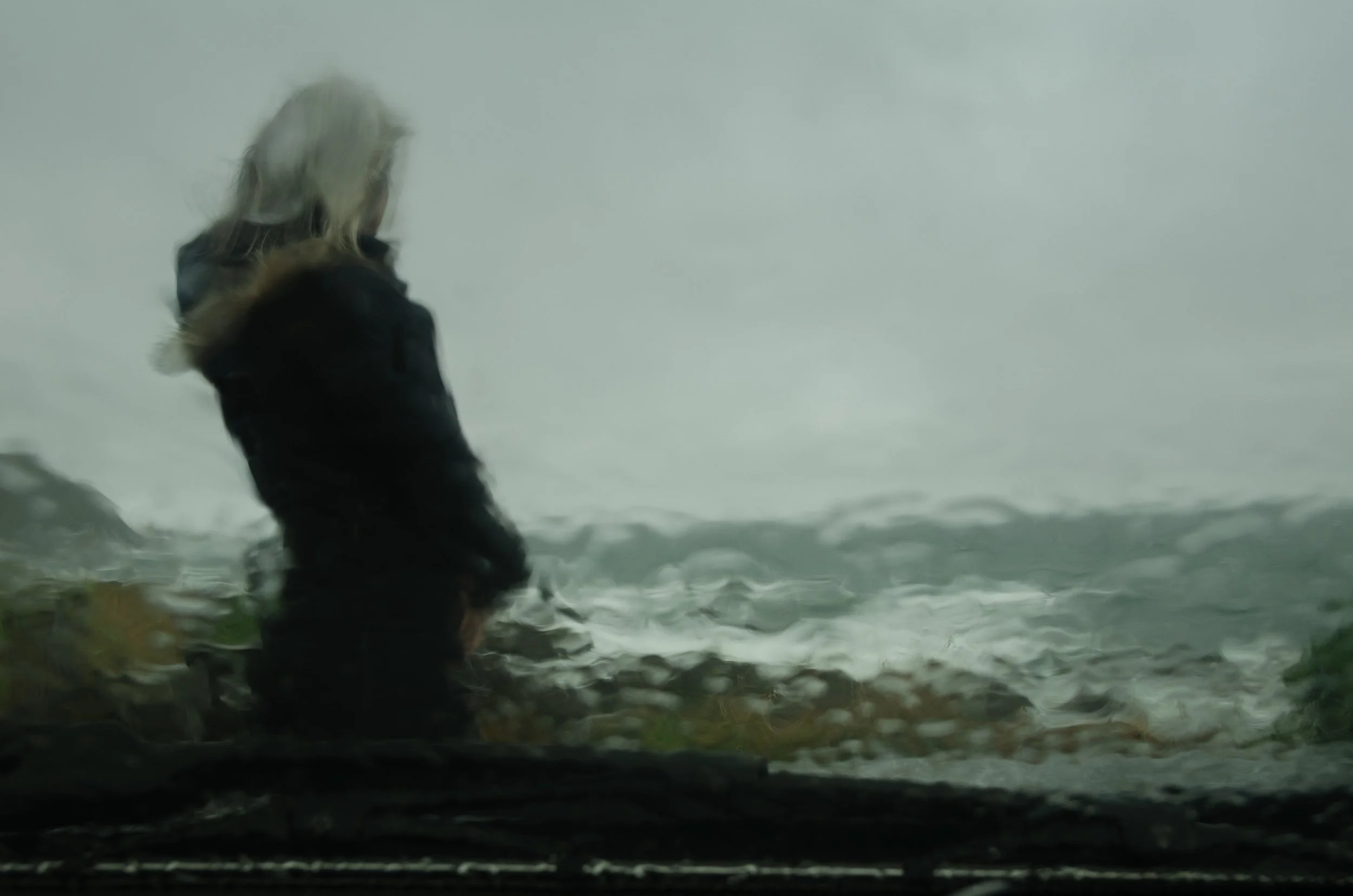 Figure distorted through rain-covered car window