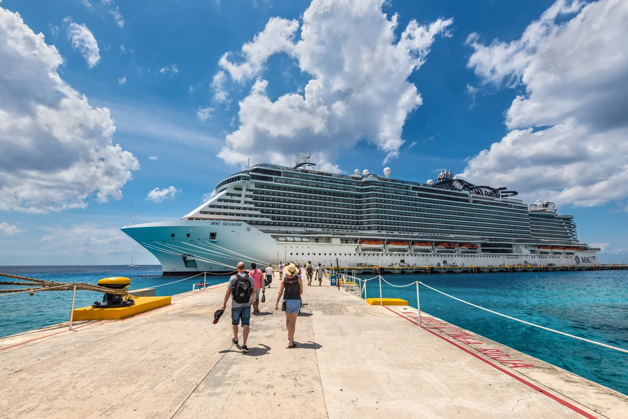 Photo of tourists heading back to a cruise ship. Are you looking for an online travel agent for cruise? Book a free consult on my website.