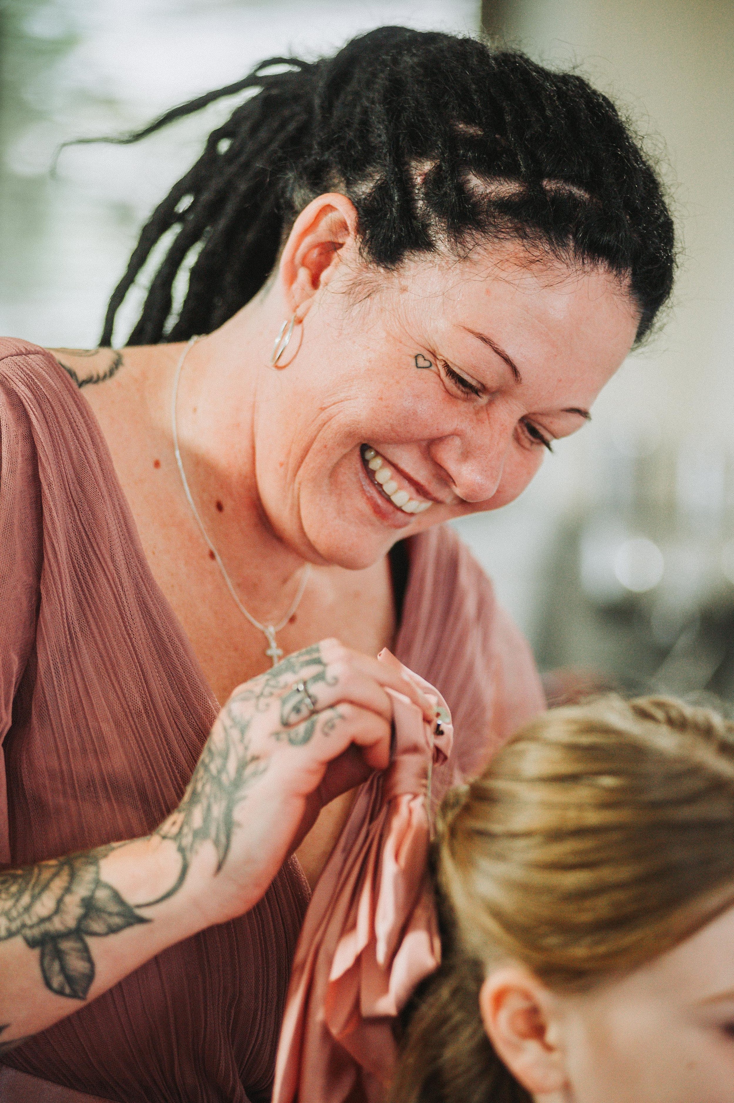 Smiling woman with tattoos styling hair
