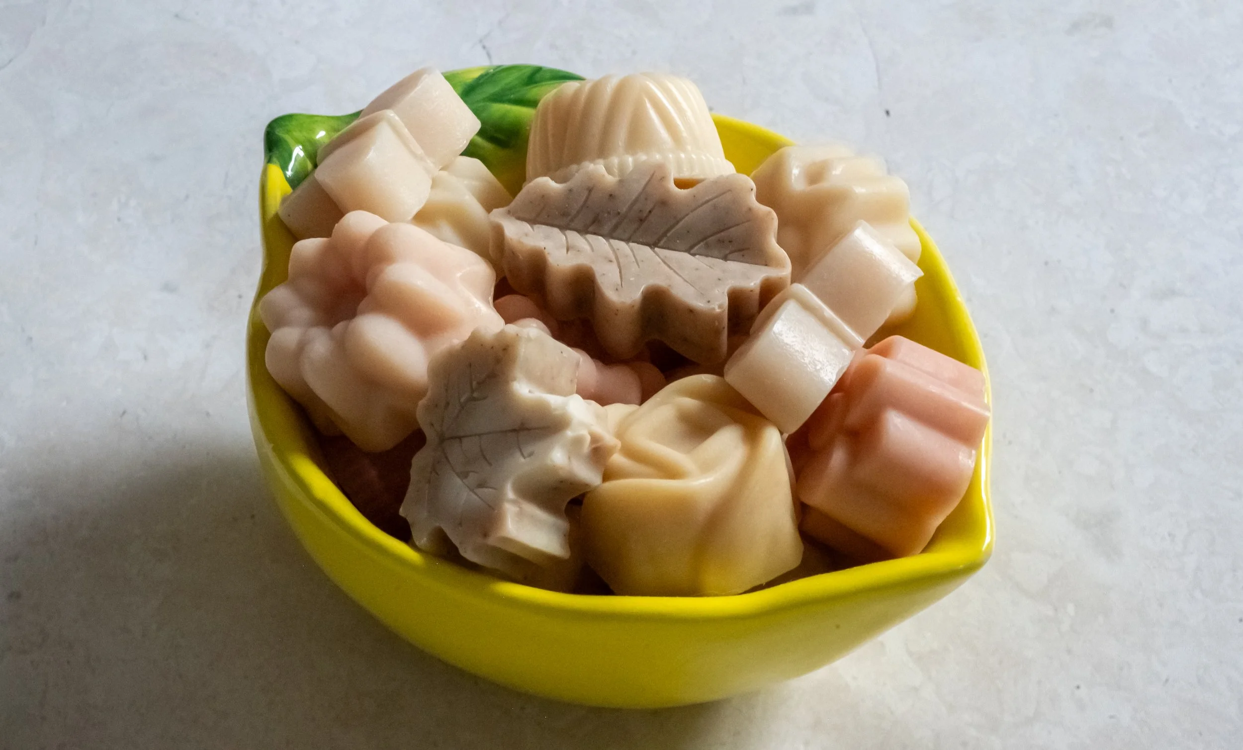 Lemon shaped bowl full of mini guest soaps made with natural organic ingredients